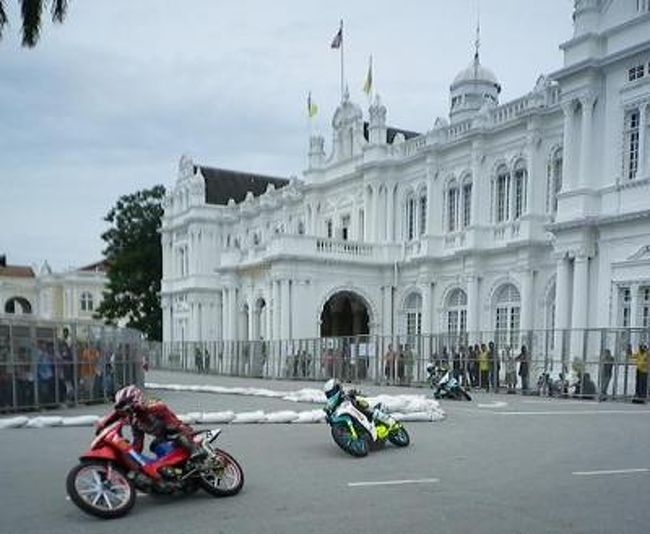 2010年12月4日・5日にマレーシアで開催された「Cub Prix」最終戦を観戦に <br />ペナン島まで出掛けてきました。 <br /><br />2009年から九州のオートポリスで開催されている「アジアンロードレース選手権」で <br />走っているアンダーボーン115（UB115）と同じ形のバイクが走る、 <br />「Cub Prix」はマレーシアでもとびきり人気のあるレースだそうです。 <br /><br />年間10戦が行われていて、今回見たのは最終戦。 <br />ペナン島の公道を封鎖して、なんと去年は７万人の観客を集めたという <br />凄いレースです！ <br /> <br />写真の白いお屋敷は、、なんとペナン市役所です。 <br />凄いでしょ？ <br />国を挙げて、街を挙げて、レースを応援している感じです。 <br /><br />今回、出かけたのはこのレースの運営を手掛けている会社の社員、ﾎﾟｰﾘｰﾝに <br />「ペナンの公道レースで、マレーシアNo１決定戦があるの。見に来ない？」と <br />誘われたからです。で、この話に乗ったのが、私と夫、オートポリスの実況アナウンサー・東さんと奥様、 <br />そして以前スーパーＧＴでも活躍していたレーシングドライバー菅一乗くんと彼女の６人！ <br /><br />菅くんは先にタイ経由でペナン入り。 <br />私たちと東夫妻は香港経由でペナン入り。 <br />街にはすでにフェンスが立ち、レースのムードいっぱい。 <br /><br /><br />ペナンは世界遺産にもなっている美しい島。 <br />まるでﾓﾅｺみたいでしょ？？ <br />その中でもジョージタウンの旧市街地に作られた公道コースはスクエア型の <br />１１５２ｍのコース。中央は公園で、 <br />裏ｽﾄﾚｰﾄの向こうは海！！ <br />もうほんとに凄いロケーションなのです！！ <br /><br /><br />広場には数万人の観客が訪れ、もうお祭り広場！！ <br /><br />ここを会場にして、「WIRA」「CP115」「CP130」 <br />「Honda icon」「Yamaha 135l」などのレースが開催されました。あ <br />参加しているライダーも13歳くらいから20代の有望ライダーまで。 <br />なかには王族の王子も！！参戦していました <br /><br />「Cub Prix」のなかでもペナンで開催される最終戦は公道ということもあり、<br />抜群の人気と知名度を誇っています。<br />なにしろ公道レースなので、観戦料は無料！！なるほど人気なワケですね。