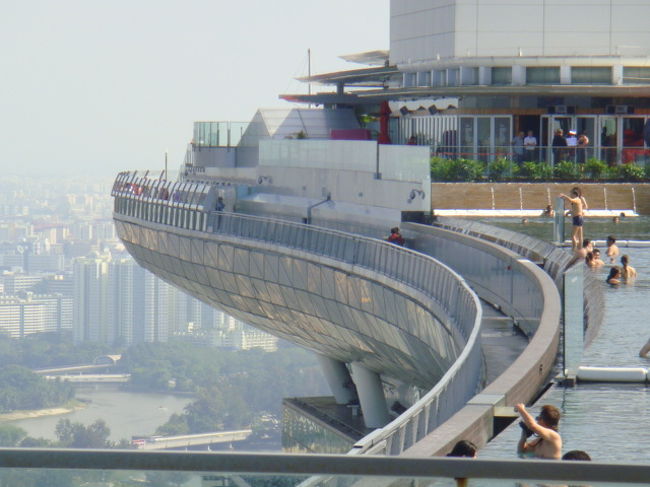去年シンガポールを訪れた時、マーライオン側から見えてた建設中の柱に船が乗っているみたいに見えていた建物。<br /><br />現実離れしている設計に驚くというよりも、笑ってしまった私達。<br /><br />完成したら泊ってみたいね～。ということでゴルフ見ながら泊ってみることに・・・。<br />前評判があまり芳しくない感じだったんでどうかな？<br />という不安もあったものの、泊ってみなくちゃわからないよね。<br /><br />ということでホテルの公式サイトから予約をしたのですが・・・。<br /><br />本当に色々ありました。（笑）これから検討している方の参考にでもなれたら幸いです。<br /><br />写真は船の形の部分を横から撮ったものです。小さなカメラでズームなのでクリアな写真ではありませんがこの角度が面白いかな～と思いました。