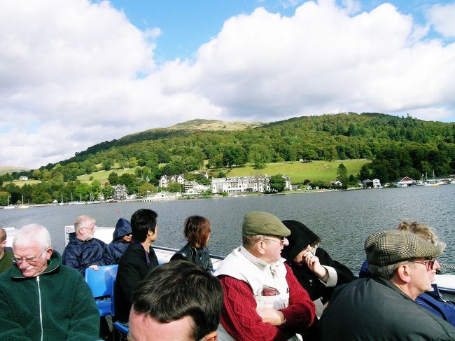 湖水地方　ウィンダミア湖　2003.9.23<br />Windermere in The Lake District<br />湖上を吹く風の寒さは身震いするほどで、早く着けば良いのにと・・・。<br /><br />ロンドン・湖水地方の旅2003②湖水地方<br />年に一度の2003年の海外旅行は、1997年以来のロンドンでした。自動車会社のエンジニアとして出張で何度も訪れたイギリスですが、1997年に特許庁関連の財団法人へ移った年の９月末、ダイアナ妃の事故死から１ヵ月後に長女と行って以来です。9月末までの夏休みを利用したフライト・ホテルセットのJTB個人ツアー7日間でした。（ヴァージン・アトランティックとロイヤル・ホースガーズ）<br />2003.9.23（火）<br />今日と明日は湖水地方への1泊2日の小旅行です。<br />エンバンクメントから地下鉄でユーストン駅へ行き、急いで売店で朝食のパンとコーヒーを買い13番線のグラスゴー行きに乗った。6:20分発だが、まだ外は薄暗い。6:40ごろになってようやく日の出を迎えた。しばらく走ると左の車窓から雲を背景に虹が見えた。<br />単調な緑の景色がつづき、牧場の牛や羊が目につく。またイギリス独特の根元が太くなった巨大なサイロのような火力発電所を見かけた。9時過ぎにはすっかり晴れた。<br />10：06に湖水地方の入り口のオクセンホルム駅に到着し現地人の女性ツアー・ガイドの迎えを受けた。<br />9名のツアーでミニバスの運転手兼ガイドが英語で二日間案内してくれた。<br />まずウィンダミア湖のほとりにある湖水地方観光の拠点ボウネスのB&amp;Bサンダウン・ケントンGH（ｹﾞｽﾄﾊｳｽ）へ落ち着いた。<br />午後は12時に映画館前に集合し、ミニバスでウィンダミア湖の北側を半周してニア・ソーリー村のヒル・トップ農場へ向かった。ピーター・ラビットの作者ビアトリクス・ポターがここに購入した古い家は350年前、200年前と100年前の3つの部分からなる古いものだ。帰りは湖上遊覧船でボーネスに戻った。湖の上からは周囲の山々の景色の素晴らしさに感動したが、寒さによる震えもあったかもしれない。これらの景色を職場のパソコンの背景にしていたこともある。<br />ボーネスに戻り、街中のレストランでアフタヌーン・ティーをして休んだ。窓の外に見慣れない鳥が見えたので店のマダムに訪ねたらカラスcrowとのことだ。日本のカラスより一回り小さい。<br />夕食はボーネスの街中のBigeyというレストランを予約し、同行の若い女性で一人参加の鈴木さんを誘い、イギリス伝統のロースト・ビーフのコース料理を楽しんだ。<br />Ｂ＆Ｂはツインの6畳ぐらいの広さだったがスティーム暖房がされて快適だった。外は星がすごくきれいで、北斗七星もよく見えた。<br />2003.9.24（水）<br />7時ごろ起床して朝食前にホテルの周辺を散歩した。静かで落ち着いた街並みで、建物はかなり年を経ているように見える。<br />8：15に２階の食堂で朝食。宿主のジョージ・アイリーンさんが作ってくれた、ソーセージ、エッグ、マッシュルーム、焼きトマトのイングリッシュ・ブレックファストで、トーストに自家製マーマレードと紅茶。<br />９時に迎えの車に乗り湖水地方の九つの湖めぐりに出発した。メンバーは全員昨日と同じで１３名。ルート･マップとＭＤによる日本語による案内付だった。<br />いくつもの小さい湖は湖面が鏡のように静かで周辺には人の住む気配はなく、静まり返って神秘的と言ってよいほどだ。<br />昼食はフィッシュ＆チップス（￡3.25）ですごく美味しかった。<br />鈴木さんがビネガーをかけて食べるのを教えてくれた。<br />３時にボーネスに戻りいったん解散し、買物時間には羊のぬいぐるみやピーターの置物などを買った。<br />4：30にＢ&amp;Ｂ前に集合し、オクセンホルムまで送り届けてもらった。5：41発のロンドン行きVirgin Trainで帰途に着いた。車内でビールとサンドイッチを買って夕食の代わりにした。途中はウトウトしながら・・・？<br />21：17　予定通りEUSTON駅に無事着いた。<br />２日間の湖水地方の旅は楽しかったが、少々疲れた。<br />撮影　Nikon Coolpix5400 <br />　　　CONTAX RX PlanerT＊1.4/50<br /><br />現地の日の出・日没時刻はこのクチコミ記事で簡単に調べられます。<br />http://4travel.jp/overseas/area/europe/france/mont_st_michael/tips/10177076/<br /><br />お気に入りブログ投票（クリック）お願い<br />http://blog.with2.net/link.php?1581210