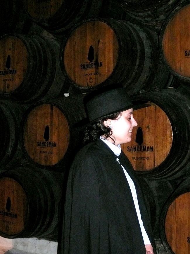大航海時代が一段落した18世紀初頭、ポルトガルを窮地から救ったのがポートワインであった。<br /><br />現在でもヴィラ・ノヴァ・デ・ガイアには30軒ものシッパー（ポートワインの醸造・輸出商社）があるらしい。<br /><br />その中でもコインブラ大学の制服の黒マント（コインブラでの「パシュタ（鞄）に祝福を与えるミサ」を楽しみに）と、やはり黒のソンブレロのトレードマークがカッコイイ「サンディマン」を見学。<br /><br />文字通りトレードマークのどおりの装いに身を包んだ、美人ガイドの歓迎を受け、スライドを含め、判りやすい写真と説明の後、何種類かの試飲を楽しみ、帰りの皆の手に「サンディマン」の袋がぶら下がる。<br /><br />ドウロ川クルーズ旅行マップ<br />http://www.geocities.jp/tshinyhp/portugal/portugalmap/porto/frameportmap.html<br />