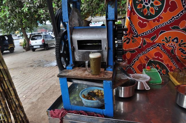 インドで見かけたさとうきびジュースのお店。<br />手押し車に木製の絞り器を載せたものや、さとうきびそのものを装飾に使ったお店もありました。