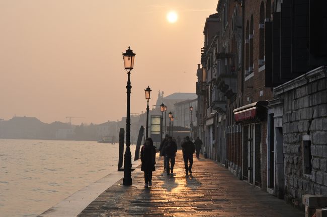 父娘コンビのイタリア個人周遊旅行で、ベネチア（Venezia）に3泊しました。22年ぶり2回目の滞在でした。<br /><br />ベネチアは、ベニス、ヴェニス、ヴェネチア、ヴェネツィアなど日本語表記は色々変わりますが、水辺の街並の美しさ、ゆったりとした時間の流れは変わりません。時間を忘れて行き交う船など眺めてたたずんでこそ、街の良さを存分に味わえる街です。<br />特に春霞のかかった朝と夕刻は穏やかと優しさのある美しさでした。<br /><br />穏やかなヴェネチアを味わいたくて、大潮アクア・アルタ（acqua alta）と華やかなカーニバル（謝肉祭）を避け（それにカーニバル中はホテル代も高いですから）、カーニバルが終わった翌日から滞在しました。そのおかげでホテル、街中とも空いていました。<br /><br />今回は、宿泊がベネチア本島南のジューデッカ島（La Giudecca）で、本島へ散策に出かけたり、ムラーノ島（Murano）へヴェネチアングラスのショッピングに出かけたりと、無料シャトルボート、水上タクシー（Motoscafi）を使用しての移動はありましたが、橋、桟橋、広場でたたずんだり、カフェやホテルでくつろいだりと、ゆったりと過ごすことができました。<br /><br />パリとともに、またもう一度訪れたい街の１つです。<br /><br />※ 2012年5月 写真を10枚追加アップしました<br />