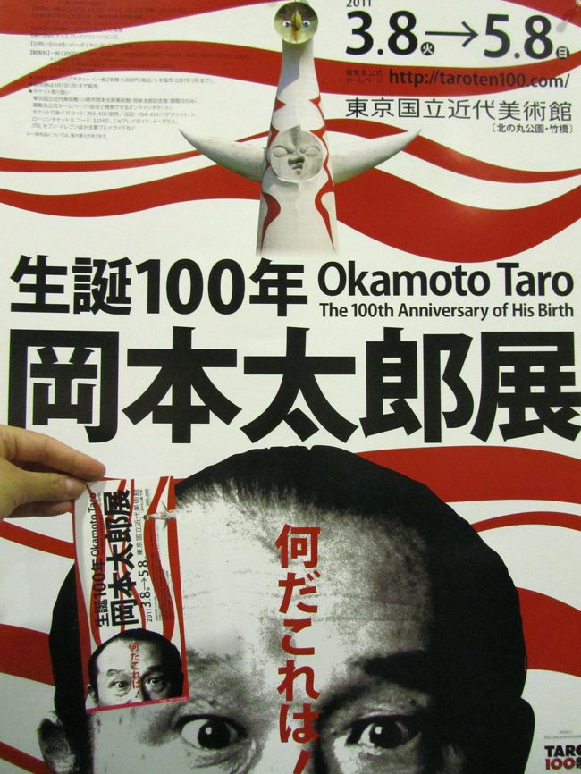 この間の雨の週末、表参道にある岡本太郎記念館に行ってから、東京国立近代美術館で開催中の岡本太郎展に行きたくなってしまいました。<br /><br />関連の旅行記<br />「子供の頃の記憶を占める「太陽の塔」の岡本太郎を訪ねて」（2011年４月23日）<br />http://4travel.jp/traveler/traveler-mami/album/10561683<br /><br />それに東京国立近代美術館の常設展は撮影OKなので、一度、撮影散策を兼ねて再訪したいとずっと思っていました。<br />というわけで、雨の日のGW中の５月３日、会期終わり間近の岡本太郎展と近代日本の美術を見に竹橋の東京国立近代美術館に行ってきました。<br /><br />ところが私は、岡本太郎の人気と会期間際の混雑を甘くみていました。<br />会場に着くと、チケット購入まで約40分待ち、それから入場制限をしているらしく、中に入るまでにさらに約20分待ち！<br />という看板を整理係の人が長蛇の列の最後尾で掲げていました。<br />つまり、中に入るまで１時間待ち、うげっ！<br /><br />───よっぽど帰ってしまおうかと一瞬思いました。<br />でも、雨の中、コレを見るために自宅から片道一時間半かけて竹橋まで出てきたのです。<br />ここであきらめたら、なんのために風邪気味で具合が悪いのを我慢してまで（！）やって来たかわからなくなります。<br /><br />結果的には、行列の進みは予想よりは速く、チケット購入待ちの最後尾に並んでから30分で入場できました。<br />その間は、読書が進みました（苦笑）。<br /><br />幼い頃の私の原風景を大きく占める「太陽の塔」の作者の岡本太郎のことは、このあいだ記念館に行くまで、ほとんど知りませんでした。<br />でも、記念館訪問と、それからこの岡本太郎展、そして２週続けて放映されたテレビ東京の「美の巨人たち」の特集番組のおかげで、随分と岡本太郎に触れることができました。<br /><br />昭和の戦時中、そして戦後の高度経済成長時代には、常識破り・型破りと思われたに違いない岡本太郎のアートと主張と叫びとエネルギー。<br />それは、すでに走り続けることに疲れた21世紀の私たち、経済成長と人間中心の開発と発展が本当に地球や人間自身にとって良いことばかりだったろうかと問い直すことを求められている私たちにとって、いろんな意味でたくさんのものをもたらしてくれると同時に、自己や周りを見つめ直すきっかけになりそうです。<br /><br />常設展の日本の近代美術コーナーでは、日本美術史の紹介本やテレビなどで必ず出てくるような超有名人や超有名作品が、期待通り、目白押しでした。<br />だけど、よく知っているつもりだった作品も、その原画を眺めると、本やテレビによって他人に紹介されるだけでは気付けない、新たな発見があります。<br />それが原画を眺める楽しさでしょう。<br />それと、画材による画質の違い、いわゆるマチエールが良くわかることも。<br /><br />そして撮影フェチの私は、気に入った作品の自分だけのカタログ作成でもするような気分と同時に、わざと一部だけ撮影して作品の印象を変えて撮ったりして楽しみました。<br />美術鑑賞しに来たんだか、写真を撮りに来たんだか。<br /><br />東京国立近代美術館の公式サイト<br />http://www.momat.go.jp/<br />企画展：岡本太郎展の紹介ページ<br />http://www.momat.go.jp/Honkan/okamoto_taro/index.html<br />会期2011年3月8日〜５月８日<br /><br />余談ですが、風邪っぴきだったのは、根性でGWが終わるまでには吹き飛ばしました。<br />のどの痛みだけは長引いて、出かけるときにはのどスプレーを必ず持参していましたが、GW中に予定していたお出かけを一つも中止しないですみました@<br />