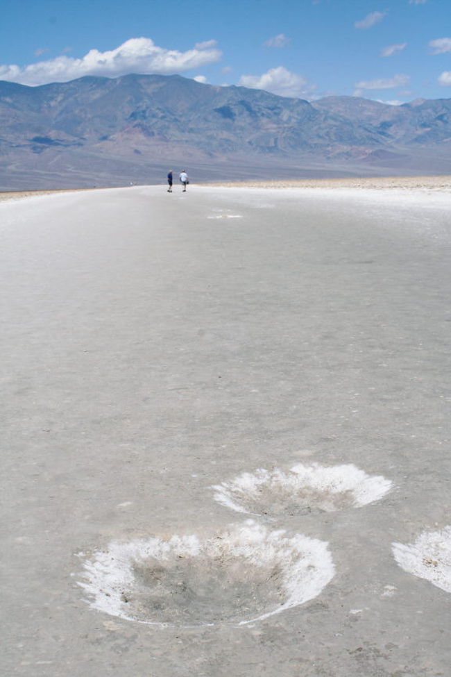 沖を寒流が流れるカリフォルニア海岸の少ない湿気は、シエラネヴァダ山脈に遮られて、内陸盆地のデスバレーは乾燥した岩石砂漠となっています。 湿潤な緑の自然に住む日本人にとって、まさに異界といえます。まず、干上がった塩湖のバッドウオーターへ向かいました。{旅日記}5月14日(土曜日) 178号線でデスバレー国立公園へ入り、カーヴを繰り返して、塩の平原であるバッドウオーターへ到着。 風が強くなってきたが、遮るものがないので、立っていられないほどだ。 駐車場前は、人の足で踏み固められており、塩のリンクのようになっている。 塩の結晶化過程で生じる多角形の文様を探したが、はっきりしたものは近辺にはなさそうだ。 あまり歩き回るのも問題がありそうなので、諦める。次に、泥が塩で固められ、大きい瘤状になった「悪魔のゴルフコース」、さらに「アーティスツパレット」へ向かいました。 − 続くこれは「加州ドライブの旅ー7」の続きです。 http://4travel.jp/traveler/eng4/album/10578766/