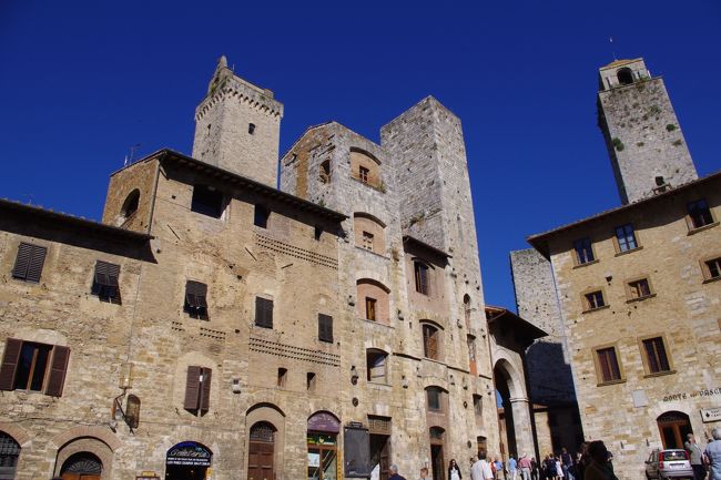 イタリア・トスカーナ地方のサン・ジミニャーノは、「塔の町」として有名で、中世の街並みをそのまま残しています。１３世紀、この町には７２の塔が建っていたそうですが、現在は１４の塔を残すのみとなっています。<br /><br />当時貴重だったサフランの生産で潤ったこの町には二つの勢力があり、塔の高さが勢力の富と権力の象徴だったとのこと。１４世紀始め、町当局が高さ５４メートルのグロッサの塔を建て、これ以上高い塔の建設を禁止。しかし２つの塔の高さを足すと一番高くなるという理屈で、「双子の塔」まで建てられた。こうして、塔の数がますます増えていったようです。<br /><br />現在、サン・ジミニャーノは、町全体が歴史地区として世界遺産に登録されています。<br /><br />http://4travel.jp/overseas/area/europe/italy/sangimignano/tips/10191951/<br /><br /><br />フィレンツェから路線バスを乗り継いでサン・ジミニャーノへ行き、半日ほど町並み散策した。アクセスが良いとはいえないが、ゆったりと散策するという面では、一番のおススメの町です。<br /><br /><br />なお、当日はフィレンツェを拠点に、サン・ジミニャーノとシエナの２つの町を日帰り旅行した。<br /><br />その際の移動方法と観光時間は、<br />　①フィレンツェからサン･ジミニャーノへは、路線バス利用<br />　　サン・ジミニャーノの観光は、約４時間<br />　②サン・ジミニャーノからシエナへは、路線バス利用<br />　　シエナの観光は、約４時間<br />　③シエナからフィレンツェへは、鉄道利用<br />だった。<br /><br /><br />フィレンツェからの日帰旅行として、サン・ジミニャーノとシエナとの組合せは、時間的にも良いものでした。シエナを後半にしたのは、帰りの移動の際には疲れていることを想定し、時間が確実なこと、乗り換えなしで帰れること、列車で寝過ごしても終着駅到着だから大丈夫だろうという理由でした。<br /><br /><br />なお、私の場合の具体的な移動等は、「クチコミ」を参照していただければ幸いです。<br />