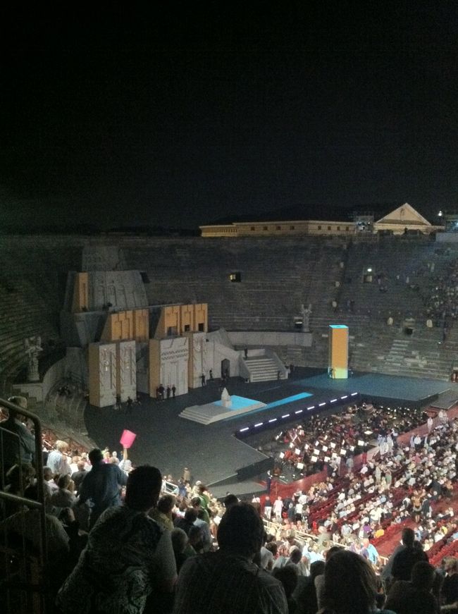 古代ローマ時代に建設されたアレーナは、当時、人vs人、人vs猛獣を戦わせる場でした。<br />そのアレーナは2000年の時を経て、世界中から毎年たくさんの人が集まる野外オペラ劇場となっています。<br />開催時期は６月下旬から９月初頭まで、今年は８９回目の開催です。<br /><br />ずいぶん前に初めてここでAIDAを観て以来、このアレーナのファンになった私が今回観に行ったのはNABUCCO、バビロニア王のお話です。<br /><br />写真を見てお判りの通り、ずいぶんと舞台から遠い遠い、高い高い、席なのですが。。。<br />それがいいのです！負け惜しみではなく、本当に。<br />ポルトローネのような場所でかしこまることも無く、隣も前も後ろも人だらけの椅子席で前に体格の大きな外国人が座ることも無く、ゆったりと壁に背をもたれて、アイスクリームを片手に、時にはあぐらをかくなどくつろいだ姿勢で楽しむオペラはまさに古代ローマ人の心情（とは大げさでしょうか。。。）!!!<br /><br />来年のプログラムももう早発表されたようですし、また行きたいと思います。
