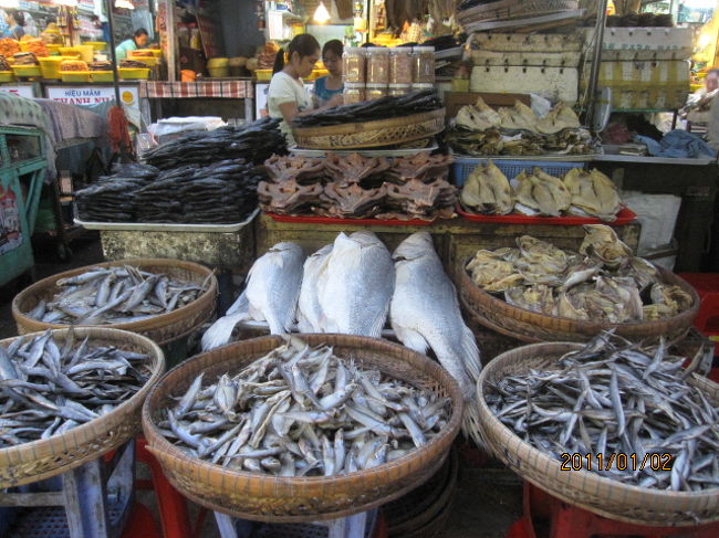 タイの地方を旅行している時、時間があれば市場なでに出向き、この地方ではどんなものが売られているのか、珍しい果物、食品などが売られているか、人々の生活はどうか、等々、庶民の生の姿がそこに現れているような気がして、極力見て回るようにしている。<br /><br />いつかコンケーンに行った時、市の真ん中に大きな市場があり、朝早くからそこへ大勢のお坊さんが入れ替わり、立ち代わりやって来ては、地べたで商売している店の人の前でお経など唱えると、店の人は惜しげもなく野菜や果物、或いはご飯お金などを包んで喜捨していたが、ベトナムでも或いはひょっとしてそんな光景も見られるかも知れない、との期待もあった。<br /><br />市場の中では煌々と電気がついてはいるが、まだ早朝で、買い物客の姿は殆ど見えず、これから開業の支度をしている状態だった。ここは海鮮市場なのか扱っている商品は魚類が多く、その大きさから言って、川魚というより海の魚で、漁船は海で釣った魚をこのメコンを遡って約１００数十キロ、この市場まで運んでくるのだろう。<br /><br />大きなイカの干物とか乾物類も多く、値段を見ると驚くほど安く、こんなところで買い付けて、日本に送ればひと財産作れるかも知れない、などと腹算用もしてみるが、目先の利く人はとっくの昔にそんなｋとはやっているに違いなく、素人が手を出すようなことでもないだろう。<br /><br />市場を一巡し、漸く陽も上り、ホテルに戻ると丁度７時。これからパンとコーヒー、バターにジャムにベーコンエッグの、正にＣｏｎｔｉｎｅｎｔａｌの朝食を食べる。こうした朝食など食べていると、この国、町が旧フランス植民地、自国民の朝食は兎も角、外人には、こうしたフランス風の朝食を出すのが礼儀であり、慣習になっているのかも知れない。ベトナム最後の日の朝、一つの発見だった。