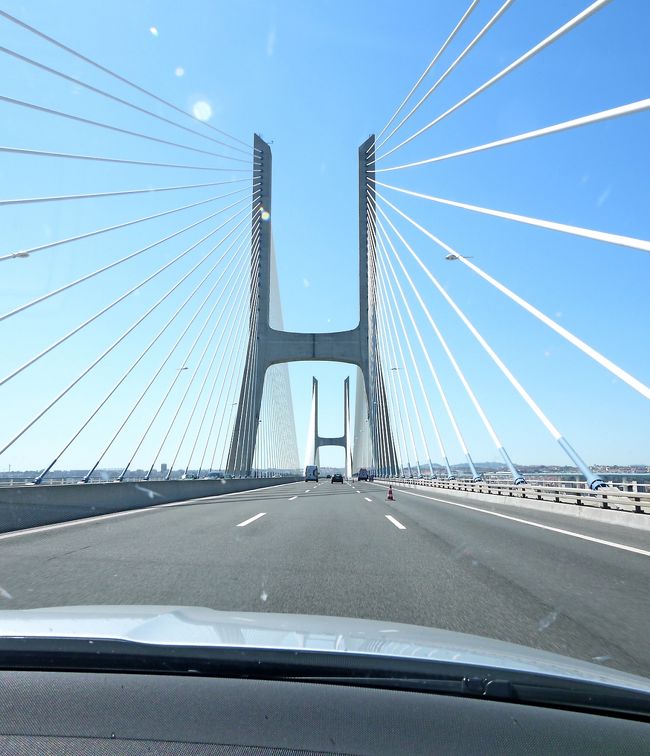 1524　A12号線　Pinhal Novoの料金所より，バスゴダガマ橋に．橋の通行料金2.4ユーロ．Tejo川が湾のようになり壮大な橋を渡る．Lisbon北部，日本でいうと外環自動車道のようにLisbon北部をかすめ通り，いくつものジャンクションを越えて，A8号線にたどり着く．わりと標識がしっかりしているので簡単にA8号線にたどり着いた．周りの気温はどんどん下がり26−27度程度と涼しい．木々も多くなり，風車や風力発電機が目立つようになる．2009年にLisboaからObidosまでバスで通った道だ．まさかレンタカーで自分で運転することになるとは思わなかった！1618Bonbarralの料金所4.55ユーロ払う．ここでLisbon近郊を離れLeiria県に入った．Obidosはもうすぐだ！（なお同僚がホワイトバランスを間違えやたら青い写真が多いのはご了承ください）