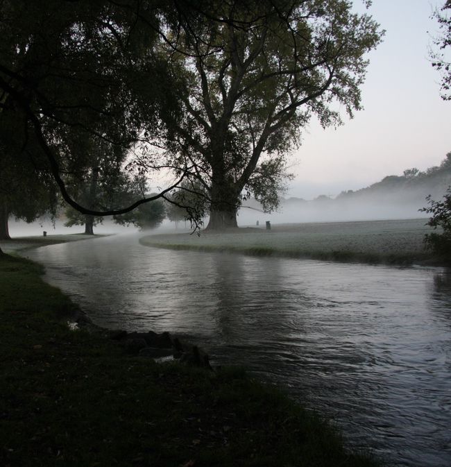 朝霧が立ち込めるミュンヘンのイギリス庭園　　2011.10.23　7:49<br />English Garden in early morning was cold and frosty. <br /><br />先に公開した「2011ヨーロッパ鉄道の旅12日間/概要」http://4travel.jp/traveler/810766/album/10617323/に続いて個別の都市ごとの旅日記に基づいた写真旅行記の連載を進めます。<br />第11回はミュンヘンの中心市街地の北東に隣接する広大なイギリス庭園の散策です。<br />イギリス庭園Englischer Gartenの面積3.7Km2はセントラルパーク3.4Km2、ハイドパーク2.5Km2より大きく、世界有数の都市公園。<br />はじめ練兵場を作る予定地が庭園になったのだそうです。 <br /><br />2011.10.23（日　Sun）<br />昨夜は10時ごろ寝たので5時半ごろには起きてしまった。<br />朝食は別料金なので外のカフェで食べることにしていたが、それまでかなり時間があるので紅茶を煎れてカップ麺を食べた。　地図とガイドブックを見ながら今日の予定をメモ張に書いた。　<br />午前中はオリンピック公園とBMW博物館、午後はドイツ博物館と10月マーケット。<br />支度が速くできたので日出を見にイギリス庭園あたりへ行くことにした。<br />Rosenheimer駅の自販機でトラベルカードを買うのに苦労したが、操作（タッチパネル）を教えてもらってなんとか買えた。１日券　9.9ﾕｰﾛ<br />マリエン広場駅で乗り換え、２駅目のUniversitatで降りてイギリス庭園へ入った。<br />まだ日の出前で広大な緑の草地は一面霜でまっ白だ。寒い！<br />公園内を流れる川の周辺は朝霧が立ち込め、モノトーンのなんとも幻想的な光景に感動し立ち尽くしてしまった。言葉での説明は参考にならないのでこの辺で止めよう。<br />日曜日のためか寒い朝早くから何人ものジョッギングや散策を楽しむ人を見かけた。<br />小高い山の上の展望台から眺める景色はじつに雄大で、視界に入る教会の塔がなければ、到底都会の中の庭園とは思えない。<br />2時間あまりの散策の間に陽が射すようになり、霜の草原も緑色を取り戻してきた。<br />寒さと空腹も我慢の終わりにしたいので、庭園を出て、近くのパン屋MULLERで熱いコーヒーとチョコ・パンを食べてホットhotした。<br />Universitat駅の前は文字通り大学で、「賢者のコンテスト」の参加者かもしれない学生が集まっていた。<br />ここはルートヴィヒ・マクシミリアン大学（ミュンヘン大学）だ。<br /><br />今朝考えた見学予定の前のイギリス庭園で感動的は風景をたっぷり楽しんだので、予定のオリンピック公園は止めることにした。<br />一人旅の気軽さで臨機応変に対応できるのがよい。<br />このあとはオリンピック公園となりのBMW本社に付属するBMW博物館を見学します。自動車エンジニアの私は、今からわくわくだ。<br /><br />撮影　CANON EOS40D EF-S17/85,EF-S55/250<br />参考資料　<br />ﾌﾞﾙｰｶﾞｲﾄﾞ　わがまま歩き14　ドイツ<br />&quot;CITY MAP Munich&quot;Published by MPM Marketing and the City of Munich Tourist Office<br /><br />旅行記2011①～⑩は前記の概要編http://4travel.jp/traveler/810766/album/10617323/にURLの記載(ﾘﾝｸ）があります。<br /><br />第11回公開　2012.1.21　<br />毎週土曜日に新編公開予定「土曜旅画劇場」（入場無料）<br /><br />お気に入りブログ投票（クリック）お願い<br />http://blog.with2.net/link.php?1581210<br /><br />