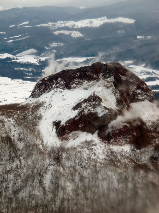 <br />有珠山（うすざん）は、北海道・洞爺湖の南に位置する標高737mの活火山。山頂は有珠郡壮瞥町にあり、山体は虻田郡洞爺湖町、伊達市にもまたがる。<br /><br />20世紀の100年間だけで実に4度もの噴火活動が観測された、世界的に見ても活発な活火山である。<br />二重式火山で、直径約1.8kmの外輪山の中に大有珠（737m）、小有珠などの溶岩円頂丘や、オガリ山、有珠新山（669m）などの潜在円頂丘が形成されている。また山麓にも溶岩円頂丘の昭和新山や、潜在円頂丘の金比羅山、四十三山（明治新山）などを有している。<br />1663年以降の活動はケイ酸 (SiO2) を多く含んだ粘性の高いマグマによるもので、噴火前には地殻変動や群発地震を発生し、噴火に伴って溶岩ドームや潜在ドームによる新山を形成するのが特徴である。<br />2007年、昭和新山とともに日本の地質百選に選定された。<br />（フリー百科事典『ウィキペディア（Wikipedia）』より引用）<br /><br />有珠山ロープウェイについては・・<br />http://wakasaresort.com/usuzan/<br /><br />洞爺湖有珠山ジオパークについては・・<br />http://www.toya-usu-geopark.org/<br /><br />北海道スペシャル4日間【プチ贅沢コース】　トラピックス HTT<br />2日目	１２月２２日（木）<br />ホテル（7：30発）＝＝＝＝○昭和新山（約30分）＝＝＝○洞爺湖（約20分）＝＝長万部＝＝森町（名物イカ飯の試食/約30分）＝＝北海道昆布館（約20分）＝＝○函館ベイエリア（約40分/はこだてクリスマスファンタジーも）＝＝○函館元町散策（約30分）＝「函館夜景観賞」＝ ＝＝湯の川温泉（泊/18：00着）　＜バス走行距離：約220ｋｍ＞	【宿泊先：湯元　啄木亭】<br />表紙は　昭和新山の雪景色