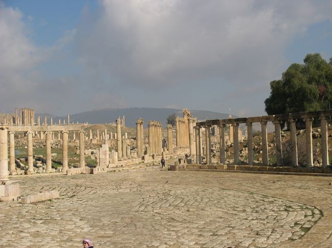 アンマンから日帰りで行けるところに古代ローマ都市の遺跡がある。ＪＥＲＡＳＨ（ジェラーシ）である。北バスターミナルからバスで45分程度。タクシーの運転手さんにアラビア語で書いた北バスターミナルとジェラーシをみせれば簡単にバスターミナルまで行けます（2ＪＤ程度）。ちゃんとジェラーシ行きのバスが出る場所で下してくれます。<br /><br />バス代は1ＪＤ以下で実に安い。バスをジェラーシの街の少し手前のサークルの所で降りれば、遺跡は目の前にあります。ちょうど凱旋門が見えるところです。その凱旋門に向かい左下側がチケット売り場と遺跡の入り口になります。<br />なお、バスは現地の人だけで外人はわたし一人でしたが、バスの運転手さんが降りるバスを教えてくれました。<br /><br />帰りも同じ場所でバスに乗れば北バスターミナルに帰れます。<br /><br />のんびり観て3時間程度なので、ちょうど日帰りにはぴったりの場所となります。<br />なお、遺跡内にレストランがあり、ビュフェ形式のランチを提供しています。10ＪＤでてごろです。<br /><br />こんなに簡単に行けるとはヨルダンは旅行がしやすい！<br /><br />1月は雨や雪が降る季節でもあります。東京の冬より暖かいですが、セーターとダウンで少し暑いか程度です。マフラーや手袋はいりません。雨が降ったらあきらめて下さい。現地の人には少しでも多くの雨が降って欲しいからです。