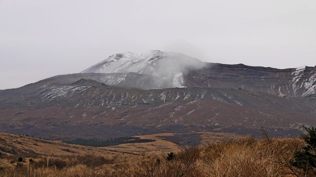 冬の寒いどんよりと曇った日，友人が車で連れて行ってくれたのは阿蘇．幸い雲が高く山は見えるが，ところどころ雪をかぶったちょっと荒涼とした風景．2010年9月に熊本出張で来たときは，晴れてとてもきれいだったが，今回は寒い寒い．気温は草千里で0度，大観峰で2度．特に大観峰では風も強かった．それでも観光客は結構いる．1109草千里，1130草千里展望台，1213大観峰，1256宮路駅前，これから高森へ田楽を食べに行く．<br />前の大観峰へのドライブは熊本・名古屋・室蘭出張旅行2-かぶと岩，大観峰からの阿蘇山の眺め<br />http://4travel.jp/traveler/suomita2/album/10503227/<br />季節の違いに驚かされる