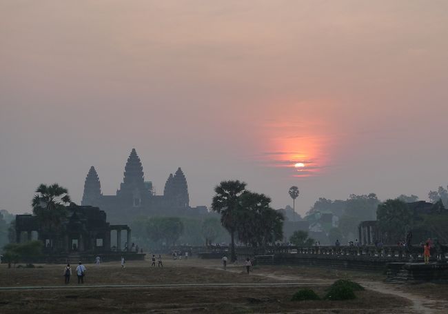 2012年2月、短い冬休みを利用してカンボジアのアンコールワット遺跡とベトナム北部のハロン湾に行ってきた。<br />今回は時間的制約もあり、ツアーで回った。<br />旅程は<br />1日目　成田～（ハノイ経由）～シェムリアップ<br />2日目　アンコールワット、アンコールトム等の遺跡めぐり<br />3日目　トンレサップ湖の水上生活村訪問、シェムリアップ～ハノイ～ハロン湾<br />4日目　ハロン湾クルーズ、ハノイ周辺観光<br />5日目　ハノイ～成田<br />という現地3日間の弾丸ツアーだったが、主だったポイントを効率よく見て回ることができた。<br /><br />その１では、アンコールワットを中心に紹介する。日の出の様子と、夕陽に照らされた姿を掲載する。