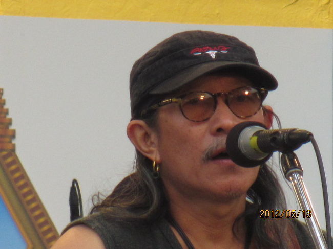 全く残念！　無念なり！　カラバオ（???????）の最初のＩｎｔｒｏの曲を全曲動画で収録したのだが、その後、宗教のコーナーでカエサコ師に会うことができ、写真を撮ろうとしたら、メモリー不足の表示が出、慌てて撮影済みの写真を削除していったら、気づかずカラバオのナイスショットの動画まで削除してしまった。残念の極みであるが、後の祭り。覆水は盆に戻らない。<br />しかし今日のこの日の熱狂は自分の記憶の中に永らく保存されるであろう。この熱狂とオーラ。目の前の日本人はカラバオの曲に合わせ、身体を小刻みに上下させていた。右後ろの若いタイ人女性は大声でカラバオの曲に和していた。一フレームごとに叫びの嬌声を揚げていた。<br /><br />ヒートアップとフィーバー。歌手も聴衆も一体になっている。Ｌｉｖｅ　Ｃｏｎｃｅｒｔの醍醐味だ。先日サークルで見たバンコク国立競技場での５万人の聴衆を集めてのライブＤＶＤを彷彿させた。勿論聴衆の規模は１００分の一にも満たず、カラバオ自身、全くの収益にはならないが・・。<br /><br />タイ人の良さ、タイの人々の純朴さ、熱狂、音楽感性。いつか見たウドンタニでの夏祭、コンケーンでの出安吾（????????）、チェンマイでのナイトバザール（???????????? ）、チェンライでのセンター広場、タイのあちこちで見た人々の熱狂、それ等のものが今一度にこの会場に凝縮されている。ビデオには収録できなくても、今日ここでカラバオのライブを見、聞けたことは生涯の思い出として残されるだろう。