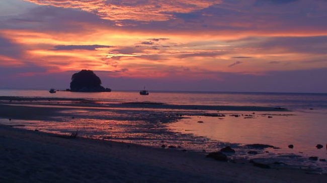 マレー半島の東、ボルネオ島との間・南シナ海の洋上に<br />ぽつんと浮かぶ島　（PULAU　TIOMAN　/ PULAU 《プラウ》はマレー語の島）が点在します。<br /><br />今回はこの中のBERJAYA TIOMAN RESORTの旅行記です。<br /><br />この島を知るきっかけは仕事先のマレー人の紹介でした。<br />”休日が3日続いて、10月から2月の間でなかったら是非この島を訪問したほうがいい。”<br />だいたいこの国の祝日は、州都の王様の誕生日とかで突然決まることが多く全く予定が立たないのですが<br />今回は半ば強硬に休みをとることにしました。<br />（あとで判ったのですが10月から2月はモンスーンの影響で南シナ海が荒れるため、この期間はティオマン島では外洋に出て釣りが唯一のアクテビティようです。）<br /><br />この島へのアプローチは３ルート。<br />マレーシアの国内線プロペラ機・シンガポールから小型ジェット機・それから現地の人の利用するマレー半島東海岸からの船！<br /><br />今回はマレーシアからの2泊3日のセットツアーを利用したので、<br />国内線でBERJAYA 航空のプロペラ機をスバン空港からティオマン空港まで往復使用することになりました。<br />この飛行機は機内の圧力調整がないらしく、離陸直後に全員に配布されたミネラルウォーターのベットボトルはベコベコに凹んでいました。<br /><br />搭乗して1時間ほどで島に到着するのですが、<br />ほとんど縁がないプロペラ機の乗り心地は、ローカルのバスのようで妙に新鮮でした。<br />客層は半分が欧米人の老若男女と、いかにもお金持ちそうな中国系、それからマレー系の人が少しで日本人は1人でした。<br /><br />シンガポールからの乗客はイミグレを通りますが、国内線の乗客は当然フリー。<br /><br />この空港の山小屋のような空港施設を出るとすぐにゲートがあって公園の管理費？<br />（ティオマンマリーンパーク保護基金と呼ばれている）を1人・５RMを徴収されます。<br /><br />その後、ホテルのピックアップのバスで10分ほど走れば目的地に到着できます。<br /><br />受付で英語のチェックインを済ませたあと、ロッジのような客室に案内されます。<br />それぞれが２階建て１部屋ずつ専用の階段も設置されていたので、<br />意識しない限り周囲の人と顔を会わせることはありません。<br /><br />昼過ぎに到着して、英語放送しかないＴＶをつけるか、徒歩１分のビーチに向かうか？<br />ツアーにシュノーケリング１回が付いていたので予約しておくことにしました。<br /><br />この島でできるアクテビティというとビーチか、マウンテンバイクか、沖まで行って釣りをするぐらいしかありません。<br />けれどもそこそこの観光客がそれぞれの方法で楽しんでいました。<br /><br />マレーシアンフードは首都クアラルンプールに行けば何でも食べることができますが、この島のウリは、なんといっても南シナ海のビーチと夕日に尽きます。<br /><br />この島に行って何をしたかというと特にこれといってないのですが<br />ボーとするには向いているかもしれません。<br /><br />ちなみにホテルの昼食は１品もので、夕食は、洋食とマレー料理のビュッフェスタイルでした。<br /><br />ご参考まで。<br />