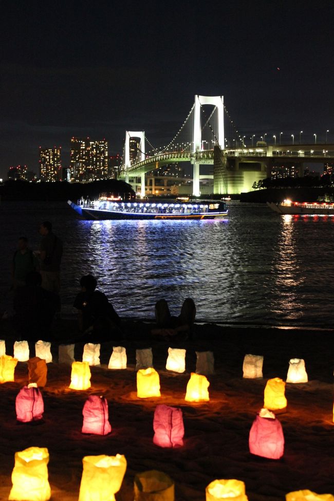今年も海の日に海の灯まつりがお台場ビーチで開催されました。<br /><br />もともとは海の安全を祈願するために始まったイベントですが、昨年は『がんばれ日本』、そして今年のテーマは『2020年　オリンピック・パラリンピックを日本に！』になりました。<br /><br />東京は前回の五輪誘致でも都民の盛り上がりに欠け、それが一因となり落選した事もあり、東京都も都民の啓蒙活動に必死です。<br />その為か、今回のデザインは五輪マークや誘致標語などオリンピックを想起させるものが中心となりました。<br /><br />夕方６時半にレインボー・ブリッジを超え、夜のお台場をひと回りして来ました！