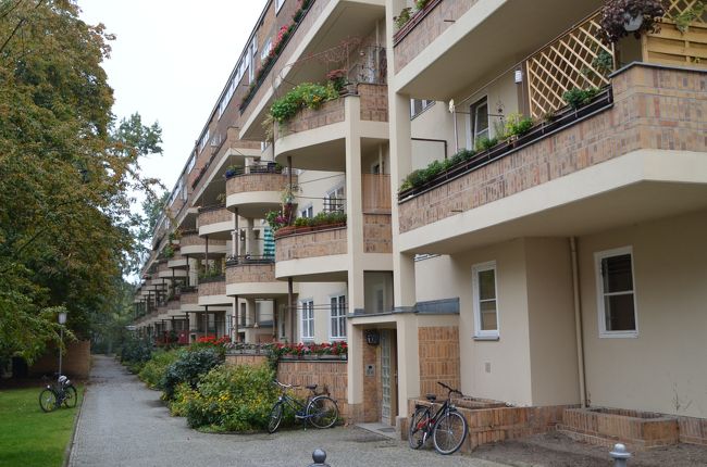 ドイツの世界遺産の18ヶ所目になる「ベルリンのモダニズム集合住宅群」を訪れた。と言っても以下の6ヶ所の集合住宅(ジードルンク)がセットで登録されているため全てを見て回ることは不可能なので、比較的都心とテーゲル空港に近いグロスジードルング・ジーメンスシュタットを訪れることにし、この地域に隣接するホテル(Holiday Inn, Berlin City West、クチコミ参照)を選んだ。この世界遺産は博物館ではなく現役の建築なので、早朝から見て回ることができるからだ。<br /><br />1.ガルテンシュタット・ファルケンベルク(トレプトー・ケーペニック区)<br />2.ジードルング・シラーパルク(ミッテ区)<br />3.グロスジードルング・ブリッツ(ノイケルン区)<br />4.ヴォーンシュタット・カール・レギエン(パンコー区)<br />5.ヴァイセ・シュタット(ライニッケンドルフ区)<br />6.グロスジードルング・ジーメンスシュタット(シャルロッテンブルク・ヴィルマースドルフ区)<br /><br />ドイツの世界遺産としては、「ヴァイマルとデッサウのバウハウスとその関連遺産群」や「ツォルフェアライン炭鉱業遺産群」に続くモダニズム建築の世界遺産である。繰り返しになるが、これらの機能、経済性優先の実用建築が世界遺産に値するのか疑問に思われる方も多いことと思う。(小生も含めて)<br /><br />これらの集合住宅群は1920年代後半~1930年代初頭、ヴァイマル共和国期に建設、当時の低所得者層に関する生活環境改善というニーズが背景にあった。実際の設計や建築を主導したは、バウハウスの初代校長ヴァルター・グロピウスのほか、ブルーノ・タウト(来日し桂離宮を評価)、マルティン・ヴァグナー(ハーバード大学教授など歴任)、ハンス・シャロウン(ベルリン・フィルハーモニーザールの設計者)といった当代一の建築家たちであり、新しい建材やデザインによって衛生的で快適な住宅作りを進めた。<br /><br />世界遺産登録には、ジードルンクそれ自体の建築物としてだけでなく、後に世界の集合住宅の様式にも影響を及ぼした点なども評価されたと言う。実際にこの建築群を見て歩くと、機能、経済性優先の実用建築でありながら、緑豊かな自然環境の中で、至る所でこれらの建築家の美意識にはっとさせられる。また、耳の長い大きな猫がいる、と思ってよく見ると野生のウサギであった。自然との共生、と言う意味でも成功例である、と言える。<br /><br />蛇足になるがジーメンス社について。我々は日本史でジーメンス事件(1914年(大正3年)の同社による日本海軍高官への贈賄事件、一大疑獄事件に発展)を記憶しているため、ネガティヴな印象を持ってしまうが、電気関連では世界をリードするスーパー優良企業、コングロマリットとして君臨している。ミュンヘンに本社を置き、近年の年間売上高は14兆円を超える。165年前の1847年、ヴェルナー・フォン・ジーメンスによってベルリンで創業、1881年に世界で最初の電車の営業運転を実現した。電信、電車、電子機器から発展し、現在では情報通信、電力関連、交通、医療、防衛、生産設備、家電製品等の分野での製造、制御関係では他の追随を許さない。福島原発の事故以後、原発事業から撤退、自然エネルギー発電事業への転換を公表している。<br /><br />ジーメンスシュタットの名の通り、この周辺は同社の建物が並ぶ。時期的にはバウハウスの活動よりも前に建設されているが、赤レンガの外観が見事に街並みに調和していることに驚かされる。機能優先のシンプルな設計は、明らかにバウハウス活動にも影響を与えている。同時に、旧本社屋などはウィーンのムジークフェラインザールを思い出させるほど堂々たるファサードを持つ。建築ファンには一見に値する地域である。