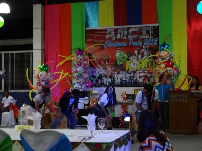 フィリピンの企業は、１２月のクリスマス前には会社が<br /><br />福利厚生の一環としてクリスマスパーティを開催します。<br /><br />クリスマスパーティと云ってもあくまでも従業員が力を合わせ<br /><br />盛り上げる素朴で簡素なクリスマスパーティです。<br /><br />会社の部門別に今年のテーマに沿って企画をしてダンスを披露し<br /><br />賞金が出るパーティでダンス以外に仮装賞やクイズに答えて正解賞<br /><br />等で従業員自らが楽しむパーティです。<br /><br />＊今年のテーマは、世界を席巻した、韓国の江南スタイル（カンナム<br /><br />　スタイル）です。カンナムスタイルを踊る友人の会社の従業員。