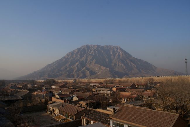 短いながらも河北省張家口の旅の最後をかざるハイライトが1000mほどの奇山、鶏鳴山に抱かれた中国に現存する最大の宿場町「鶏鳴駅」です。張家口市懐来県鶏鳴駅古村は周囲2キロほどの城壁に囲まれた、四角形の小さな村で。その売りは義和団の乱の際に八か国連合軍(あのチャールストン・ヘストンもいたんだねえ)が北京を占領するに及んで、西太后と光緒帝が西安まで逃げたとき、この「鶏鳴駅」に泊まったという歴史的事実、そして何よりも、時が止まったかのように静かにたたずむ村の中の家々、路地…まずは村の全体像を把握するために城壁に登って一周してみました。大まかな日程・1月11日午後:蔚県までたどり着く・1月12日午前:蔚県旧市街・1月12日午後:暖泉古鎮(西古堡、中小堡、北官堡)・1月13日午前:宣化旧市街・1月13日午後:鶏鳴駅・1月14日午前:北京前門界隈