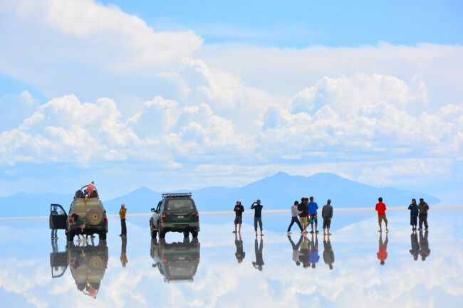 ウユニ塩原(スペイン語:Salar de Uyuni)はボリビア中央西部のアルティプラーノにある塩の大地。<br /><br />標高約3700mにある南北約100km、東西約250km、面積約12000平方kmの広大な塩の固まり。<br /><br />アンデス山脈が隆起した際に大量の海水がそのまま山の上に残されることとなりました。<br />さらにアルティプラーノは乾燥した気候であったこととウユニ塩原が流出する川を持たなかったことより、近隣の土壌に残された海水由来の塩分もウユニ塩原に集まって干上がることになり形成された大地です。<br /><br />この塩原は高低差が50センチしかないので「世界でもっとも平らな場所」です。<br /><br />そのため、雨季に雨により冠水すると、その水が波も立たないほど薄く広がり水が蒸発するまでのわずかな期間に「天空の鏡」と形容される巨大な鏡になります。<br /><br />そんな絶景に魅せられて是非とも行きたかったのですが観光をどこに頼んでいいのか分かりませんでした。<br />ほとんどがバックパッカー御用達の現地のグループツアーしかなく過酷な条件でした。<br /><br />塩湖は専門のドライバーに頼まないと観光出来ないし、数年前に大事故もありドライバーの質も問われています。<br />日本人のガイドが個人で活動している様でメールをしましたが1度返信があったもののその後は連絡がなくウユニを諦めてたのですが、旅行記NO.1に書いたようにアタカマ砂漠にあるアワシとういうホテルからチリの旅行会社(GLOVE)を紹介して貰いました。<br /><br />アタカマ砂漠の後、イグアスに行くのが妥当かなと思ってたものの、パタゴニアにも行きたいと言ったら予定に組み込めるとLANの南米周遊チケットもGLOVE Travelが手配してくれ素敵な旅行が計画出来ました。<br /><br />アタカマのホテル・アワシ(AWASI)は直接の予約しましたが、ウユニの費用とパタゴニアの費用を紹介された旅行会社に振り込むので信用のある会社でないと不安です。<br />まして何の情報もない海外の会社ですから・・・・<br />でも、アワシが高級ホテルなのでアワシの名前で信用しました。<br />Awasi - Relais & Chateaux http://www.awasi.cl/ <br /><br />ところが、なんとウユニ空港でお迎えが来ず まさかの空港で放置!されました。<br />旅行までの期間何度もメールでやり取りしこちらも念を押したのですが・・・<br />バウチャーも添付してくれてて日付けは合ってたのに、担当者のミッシェルが何故かウユニの手配会社に日にちを間違えて伝えた様です。<br />彼女も勤続10年でこんな大きなミスは初めてだったそうです。<br /><br />しかし、親切な方々のお蔭でどうにか連絡も付き予定遂行。<br />ウユニを楽しむことが出来ました。<br /><br />さて、ウユニにご興味のある方は個人ツアーの金額が気になってるのではないでしょうか。<br />通常(過酷な?笑)2泊3日なら一人$100ぐらいです。しかし5名~8名ぐらいの乗合で宿泊はドミトリーです。<br />私たちは2名で車のチャーター(ドライバーとガイド)やホテル2泊で一人$1150でした。(前日のラパスの観光や宿泊込)<br />二人で$2300は納得の価格でした。<br />ミッシェルも信用のおけるドライバーだと言うし車はチャーターですから・・・<br />(結局、日にちを間違えた事で全額返金して戴きました。申し訳なかったです)