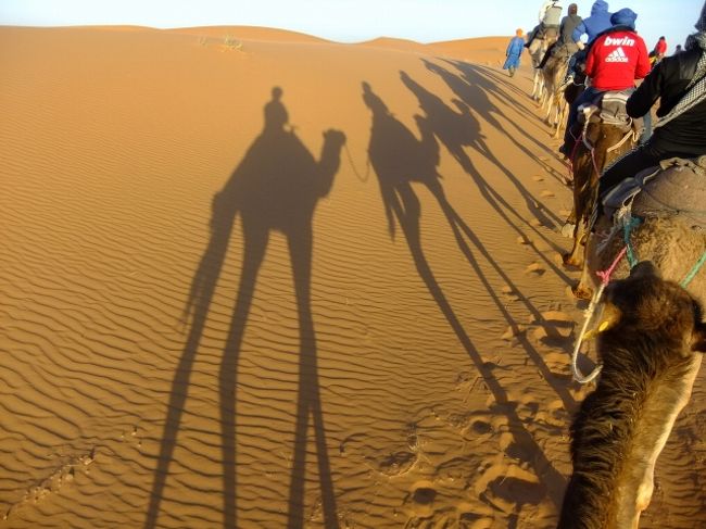 ちょうど１年前(2012年)にモロッコの砂漠を旅してきました。モロッコというと砂漠のイメージが非常に強いのですが、ガイドブックで見るようなさらさらな砂丘というのは実は少なくて、アルジェリアの国境の近くまで行かないとありません。そんな訳で、マラケシュからは車で10時間位かかります。短期間で砂漠に効率よく周りたいという場合、ツアー参加となるでしょう。私も迷ったのですが、時間があまりなかったので、前日にホテルでSahara Expeditionのツアー予約しました。マラケシュからメルズーカ(直訳で砂漠)・エルグチェビに行き、3日間で950MAD(1万円ほど)でした。フナ広場では客引きがサバク！といって勧誘しています。要らないという顔をするとイッタ？っておもしろい。当日は12人ほど乗れる小型バンが沢山あり、参加者は多そうです。ゴールデンウィーク中なんで日本人も多く、一緒に旅行することになった日本人やカサブランカからのモロッコ人など多国籍グループで出発です！