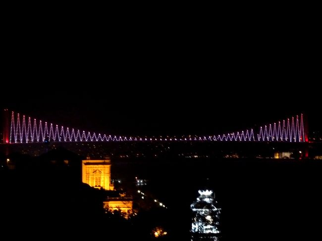 アタチュルク空港を出てすっかり陽の落ちたイスタンブールの街へ。<br /><br />ライトアップされたヴァレンス水道橋を潜るとアタチュルク橋から、やはりライトアップされたアヤソフィアとブルーモスクが闇に浮かんで望める。<br /><br />小川ＴＤが会員制のレストランだよ！とちょっと力んだトパーズは、今夜のホテルの建つタキシム広場にほど近い、ボスポラス海峡を見下ろす崖の上に有った。<br /><br />レストランの窓からボスポラス海峡大橋が、宇宙に大円を描いて踊るラインダンサー達の様に、色とりどりに光を変えるのを眺めながら、やや遅い夕食。<br /><br /><br />＊イスラエル旨いもの<br />http://www.geocities.jp/tshinyhp/israel/isrmenue/frameisrallmenue.html<br /><br /><br />