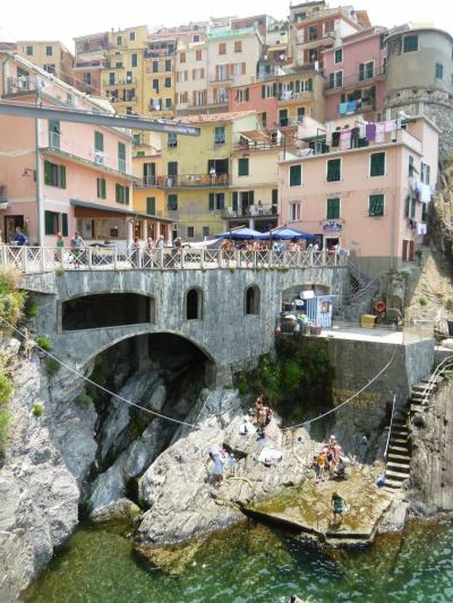 7月10日〜7月25日の14泊16日、イタリア・東リビエラへ行きました♪<br />宿泊地はジェノバ2泊・テッラロ1泊・モンテロッソアルマーレ5泊・パルマリア島1泊・セストリレバンテ2泊・ポルトフィーノ2泊・カモーリ2泊の7か所で全て絶景のジュニアスイートルーム♪<br />ジェノバ・ネルヴィ・テッラロ・レリーチ・モンテロッソアルマーレ・ヴェルナッツァ・リオマッジョーレ・マナローラ・ポルトヴェネーレ・パルマリア島・レヴァント・セストリレバンテ・カヴィ・ポルトフィーノ・サンフルットゥオーゾ・カモーリ・レッコ・サンロッコへ行きました♪<br /><br />☆Ｖｏｌ５７：第５日目（７月１４日午後）マナローラ♪<br />今日はチンクエテッレ観光♪<br />モンテロッソからヴェルナッツァへハイキング。<br />ヴェルナッツァから船でリオマッジョーレへ。<br />リオマッジョーレから列車でマナローラへ。<br />マナローラの「Ristorante da Aristide」でランチをしたら、<br />漁港へ歩く。<br />漁港といっても断崖下にある岩場がいっぱいで、これが漁港？<br />そして驚愕の光景。<br />漁港内はたくさんの岩山のようなミニ島があり、<br />その間を縫うようにたくさんの人が泳ぎまわっている。<br />しかも、所々プールのようなものも。<br />透明度が高く綺麗だが、かなり深く、泳ぐのは勇気がいる。<br />面白いことに全ての岩山にはたくさんの人でごった返しており、<br />まるで、海からの遭難者がひしめき合っているかのような光景。<br />さらに少しでも平坦な所は全て日光浴している。<br />この奇妙な光景にびっくりして、口が開いてしまう。<br />メインストリートに戻り、最後のショッピングを楽しむ。<br />これでチンクエテッレ観光は終了。<br />最後のコルニーリアは海に面していないため、興味がなく、<br />また、船上から眺めることができたので、<br />コルニーリア観光はしない。<br />列車でモンテロッソへ帰る♪