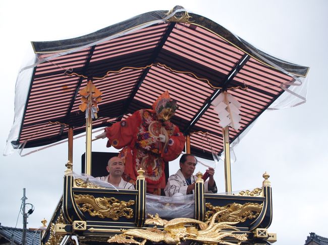 　神輿渡御の行列に続いておしゃぎり巡行が始まった。先頭1番の久保多町、2番の大町、3番の寺町、4番の大工町、5番の小町、6番の塩町、7番の上町、8番の細工町、9番の安良町、10番の小国町、11番の鍛冶町、12番の肴町、13番の長井町、14番の羽黒町、15番の庄内町のおしゃぎりに続いて16番は片町のおしゃぎりである。<br />　片町のおしゃぎりは昭和8年(1933年)に村上古建築研究会（大工：近田均、彫刻：高野茂、塗師：尾崎純治・川村三樹・川村将）によって製作されたものである。乗せ物は蘭陵王（らんりょうおう）である。見送りは、壮大な唐獅子の衝立であり、当時の帝展無鑑査の美術作家、初代小野為郎と山脇敏男の合作によるものである。<br />　曳き手が着る紺色の法被には丸に横棒の町の印が白抜きされている。2階に乗る人たちは白地に薄い水色の模様がある着物である。また、おしゃぎりに乗る子供たちのうち男の子は烏帽子を被り薄い青の装束、女の子は薄いピンクの装束である。<br />（表紙写真は16番片町のおしゃぎり）