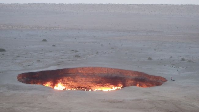 今年のお盆休みはトルクメニスタンに行ってきました。<br />一番の目玉は、「地獄の門（ダルヴァザ、Darvaza）」です。<br /><br />ここは1971年にボーリング調査＆落盤事故で空いたクレーターであり、有毒ガスの放出を抑えるためにつけた火が天然ガスの自然放出によって42年以上燃え続けているという、世界でもきわめて珍しい場所です。<br />今回の旅行では、この近くにテントを張り、昼と夜、この光景を堪能しました。<br />ここには、転落防止の柵などは一切ありません。すべてが自己責任です。掲載写真の一部に写っているように、クレーターの縁スレスレまで近づく人たちが多く、傍から見ているとヒヤヒヤしてしまいます。かくいう私も、スレスレまで近づきましたが。<br /><br />なお、このクレータの近くには、３つほど小高い山があり、うち２つからは地獄の門の赤い火が見えています。また、もう１つは休火山で、頂上付近には火口と思われるへこみが10個ほどありました。天然ガスが放出する場所になぜ火山があるのかは謎のままでした。