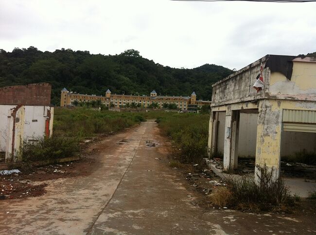 それは突然目の前に現れた。<br />ラオス北部の町ルアンナムタから片道60キロ、のどかな山間の村に巨大ホテル群！<br />どうみてもラオス建築ではない。テーマパーク、いやラブホテルのような派手な建物。<br /><br />ボーテン経済特区。<br />中国国境からわずか数百メートルのところに作られた町は、中国人御用達のカジノとして建設された。マカオ以外でギャンブルができる場所が国境からわずかな場所に誕生した。<br /><br />2004年。<br />ラオス政府の後押しを受けた中国人投資家による大胆な開発により、当時はラスベガスのようなにぎわいを見せていたのだろう。カジノ建設に伴い、ホテルが建ち、商売をする店も軒を連ね始めた。毎日中国側から観光客が山のように押しかけた。<br /><br />しかし。賭博詐欺事件、麻薬や売春などの犯罪が多発。<br />中国政府はラオス政府に圧力をかけカジノを廃業させ、その後ホテルや商店の廃業も相次いだ。2010年、3年前の話だ。<br /><br />ゴーストタウンとなったこの町は現在、少数の中国商人やラオス人たちが残り商売を続けているそうだ。<br /><br />開発がされる前、かつてはのどかな田舎村だったボーテンは、カジノ建設に伴い国境から数キロ手前のところに移転していた。<br /><br />----<br />近年、中国ラオス鉄道の拠点として、再び建設ラッシュが始まったとの記事を見た。<br /><br />☆ルアンナムタまで<br />現在、ラオス航空がビエンチャンからデイリー運行。<br />ラオス航空のHP<br />http://www.laoairlines.com/<br /><br />☆ルアンナムタからボーテン経済特区まで<br />トゥクトゥクで片道1時間10分ほど。値段は要交渉。<br />1日ツアーの後に行ってもらって追加料金200,000キープ。町までの往復だと300,000キープくらいか。