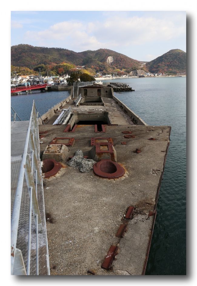 ■鉄筋コンクリートでできている船「第一・第二武智丸」／広島県呉市安浦町<br /><br />　戦時体制下であった日本では輸送手段の貨物船も、造船用鋼材も極度に不足していた。<br />　舞鶴海軍工廠技術中佐であった林邦雄は800トン級貨物船をコンクリートで作る承認を艦政本部から得た。この計画に大阪府土木会社の武智昭次郎が事業に名乗りを挙げ、兵庫県印南郡曽根町（現在の高砂市）の塩田跡に新設された武智造船所でコンクリート船体が建造され、艤装は岡山県玉野市の三井造船玉野で行われた。寸法などは戦標船Ｅ型に準じて製作された。<br />・構造<br />　武智丸は鉄筋コンクリートで船体を作られたため、鋼鉄船に比べ若干重く積載量が少ない（載貨重量940トン）という欠点があった。<br />　しかし、1945年（昭和20年）5月24日、第二武智丸が関門海峡を航行中、部崎灯台付近で米軍が瀬戸内海に敷設した機雷に触雷したが被害は小破と意外に軽く、鋼製船にさして劣らなかったという。<br />　船体のコンクリート断面厚さは喫水線以上で12cm、それ以下は13〜18ｃｍと厚みを増し、船底部では25ｃｍにも達した。<br />　コンクリートの配合は容積比で1：1.5：3（セメント：砂：砂利）、一般の鉄筋コンクリートの標準配合は1：2：4。船舶用の特別仕様の配合がなされた。<br />　セメントは大阪窯業セメント会社の普通ポルトランドセメント、砂利は揖保川下流のものが、また砂は海砂が使用された可能性が高い。<br />　また、船体外側にわずかに残る黒っぽい物質から、防水を兼ねてアスファルトを塗装されていた可能性が高い。<br />　船首は衝突のよる破損防止のため鋼板に覆われて強化されている。<br />　被曳航油送船とは違い機関部（三井造船玉野製・750馬力ディーゼルエンジン）が装備され、自力航行が可能であった。<br />・戦後<br />　戦後２隻のコンクリート貨物船は、第一武智丸はエンジン故障で呉市警固屋付近で放置。第二武智丸はどうやら使用可能であったため大阪商船が払い下げを受けたがまもなく廃船された。<br />　おりしも広島県の安浦漁港が防波堤がなく、1945年9月に来襲した枕崎台風をはじめ台風襲来のたび、漁船等に被害を被っていた。<br />　安浦漁協側は県当局に防波堤設置を陳情したが、安浦漁港沖合いの海底が軟弱地盤のため、当時の土木技術では建設に巨費がかかると県当局側は難色をしめした。<br />　代案として、呉港の第一武智丸と、大阪港の第二武智丸の二隻を防波堤として転用することになった。1947年に大蔵省から船体の払い下げを受け、1949年（昭和24年）に基礎工事を開始した。<br />　まず海底の泥を浚渫し粗ダ沈床（0.9ｍ）を敷き、置換砂（1.6ｍ）を敷きつめた上で、「第一武智丸」と「第二武智丸」の船尾同士を繋げる形で位置を決めた。<br />　沈設は満潮時を待って行われた。スクリューシャフトを抜き、また船体底部数箇所に穴を開け海水を船内に入れ２隻を沈めた。<br />　そののち船体両側に捨石をおくなどして船体を固定し1950年2月に完成した。沈設当時の二隻は上部構造物がほぼそのまま残されていたが、朝鮮戦争特需でスクラップ価格が高騰していた頃金属製構造物の大半は持ち去られ、現在あるコンクリート船体のみの姿になった。<br />　わずかに船首部の錨巻上げ部付近のコンクリ埋め込み金具などが残されている。溶接跡は非熟練工によると思われるものであり、当時の勤労動員者もしくは学徒の手になると推測される。<br />　船首左舷には「第一武智丸」の船名が白く大書されていたが、現在は塗料が剥落し判読は難しくなっている。<br />　21世紀の現在もなお、武智丸は安浦漁港を守る防波堤として現存している。陸側の「第一武智丸」は沈設から60年以上を経て主に船首部が甲板まで沈下しているが、沖側の「第二武智丸」はほぼ沈設当時の位置にある。<br />　現地では史跡としても保存しており、漁港にある駐車場から「第二武智丸」の先に設置された防波堤端の灯台まで通路が設けられており、「第一・第二武智丸」の船体構造を見ることが出来る。<br />　ただし、風化が進行している箇所があるうえ海中への転落の危険もあるので注意が必要である。　Wikipediaより。<br /><br />【手記】<br />　寒い毎日ですね。この時期は近くにはこれと言って行くところがないので、買い物ついでに足を延ばして呉市安浦漁港にあるコンクリート船の見物に行って来ました。<br />　また、毎年の恒例行事なのですが、野呂山の氷池に飛来してきているカモたちに餌をやって来ました。