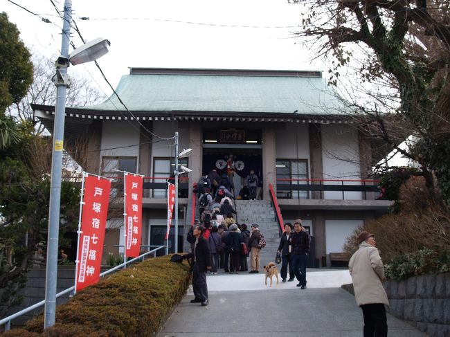 　横浜市戸塚区吉田町にある宝蔵院は真言宗大覚寺派のお寺で東峰山宝蔵院という。通称「連ぎょう寺」、「戸塚不動尊」とも呼ばれている。<br />　文化13年（1816年）の正月宥教法印記録等によれば、弘法大師が帰国後に東国御巡化の砌に留錫し、これにより一字を建立し東高野と称したとある。元は東峰山光円寺といい、中興の朝興法師は天正4年（1576年）に示寂したと古碑ある。<br />　安政の頃（1854年〜1860年）には惣鎮守八幡宮の神宮寺となり、本堂庫裏山門及び境内には御嶽山天満宮、大日堂観音堂、聖徳太子堂、地蔵尊堂、金毘羅社等の堂宇、塔、伽藍が整い規模も広大なものであったが、大正12年（1923年）の関東大震災に遭い、今日に至っては昔の盛観をみることは出来ない。しかし、先師の代より漸く寺運を挽回して、昭和50年（1975年）には本堂、庫裏、客殿を鉄筋コンクリート製の近代建築で再建し、水子地蔵尊堂、観音堂を修復し、目下金毘羅堂の再建に着手している。<br />　今年から始まった「戸塚宿七福神めぐり」の最初のお寺となり、初日の開始時間ということもあり、団体で混雑していた。毘沙門は比較的新しいものである。また、鉄筋コンクリート造の本堂ではあるが、仏像が多く安置されていて感激ひとしおだった。<br />　団体のグループも次の「戸塚宿七福神めぐり」のお寺に移っていった後に、甘酒が振舞われた。暫く振りに頂いた味の濃い甘酒らしい甘酒であった。宝蔵院では初詣の人たちに甘酒を振舞っているのだそうだ。後でWebを見ると、宝蔵院は若い住職で、甘酒を振舞っていた2人のうち、おばさんではなく、奥さんと呼ばれていた若い方が住職の奥さんで間違いなかろう。<br />（表紙写真は寶蔵院本堂）