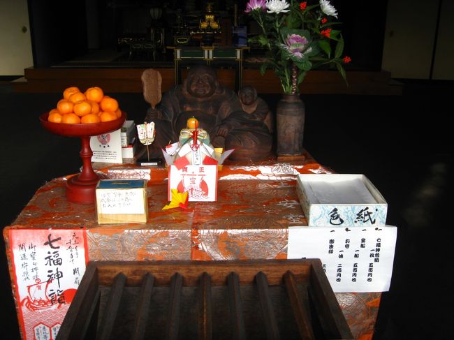 2014年1月5日(日)、歩きを兼ねて、今年も磯子七福神を巡ってきました。暮れの28日から、インドネシア駐在の下の息子の一家が来ていて(嫁と孫娘は、15日から名古屋の嫁の実家に帰って来ていた。)、凄くにぎやかだった。<br />孫娘は、本日(1/15)4歳の誕生日。物分りは良くなったが、自分の主張は絶対に通すと言った感じで、ママのいうこともあまり聞かない。我々、ジジ・ババは友達扱いである。<br />1/3、帰国した(戻って土日をゆっくりしたいとのこと)ので、一挙に静かになった。隙間が無いほど、荷物がちらばっていたので、3日は時間をかけて掃除。<br /><br />そういった訳で、暮れから正月は運動をしてなかったの。磯子七福神は珍しくもないが、サーと一週することにして、1時頃に出発。<br />今回は、家に近い方から、まず中村橋商店街からちょっと入った弘誓院(福禄寿)へ(13:09)。山門の脇に幟があるだけで、参拝の人影なし。<br />次は、すぐ裏なのだが、道が無く戻って回り込み、宝生寺(寿老人)へ(13:16)。ここも、閑散。<br /><br />国道16号を天神橋まで行き、対岸に渡り、宝積寺(恵比須)へ(13:29)。ここは、テラノホールがあるちょっと綺麗な寺なのだが、今年は改築中だった。でも、庭先に恵比須像を飾っていた。2組ほどの参拝客。<br /><br />根岸橋まで行き、橋を渡って掘割川の右岸に戻り、密蔵院を目指す。市電保存館を過ぎると、左に入る道の角に表示があった。こっち周りだと分かり易いことが分かった。密蔵院(布袋尊)にも殆ど人影無し(13:44)。<br /><br />真照寺(毘沙門天)は、磯子小の前なので、かなり中に入らないと・・とは分かっていてが、どこで曲がる・・と思ううちに、八幡橋の先に出てしまった。16号線沿いのコンビニでトイレを借りた後、浜マーケットを通り抜けて、真照寺へ(14:05)。ここは、ちょっと異風な本堂だが、ここも参拝客は殆ど無し。区が団体の巡りを毎年開催しているようだが、連休辺りなのでしょう。<br /><br />磯子旧道に戻って、金蔵院(弁財天)へ(14:15)。ちょっとけばい社である。<br />1つ残った金剛院(大黒天)が、ちょっと離れている。距離もだが、丘を登って、下ってになる。地図も持たず、方向だけを定めて、知らない道を登った。<br />岡村公園に入って梅園辺りを抜ければ良かったようだが、登る切った後、道が分からなくなり、結局、旧道を浜小に向かういつもの道に出てしまった。笹掘経由のバス通りを歩いたので、かえって時間がかかったようだった。<br /><br />金剛院にも参拝客はいないようだった(14:45)。弘明寺行きのバス通りに戻ると、ちょうど弘明寺経由のバスが来たので、バスに乗った。<br />フットサルをしてきたという長男が家に寄っているというので、急ぎ帰った。<br />彼は、昨年何十年ぶりかで再開した卓球(スポーツセンターの教室に入った。)の先生である。高校の卓球部で活躍(?)していたようだ。良かったら、これからやる?というので、伊勢佐木町裏の卓球場で初打ち。<br />この日は、久しぶりにかなり運動した。<br />冬季卓球教室は、1/14に始まった。<br />