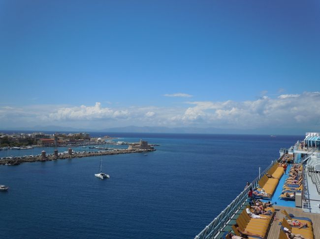 エーゲ海クルーズ乗船５日目寄港地はロードス島。<br />古代の言葉で[薔薇の咲く島」とか、ロマンチックですね！<br /><br />ドデカニサ諸島のロードス島はトルコとの国境に位置しており、<br />トルコとの距離は18キロ、ギリシャで４番目に大きな島。<br />夏のシーズンには観光客で溢れかえる人気リゾート！<br /><br />全体が世界遺産の旧市街は、中世の街そのままの姿。<br />この時期は観光客も少なく、とてもで静かで中世にタイムスリップ～！<br /><br />対照的に新市街のバザールは観光客が多く賑やかに華やいでいました。<br />タベルナやお土産屋さんの立ち並ぶ街は歩きが楽しかった～♪<br /><br />雰囲気のいいガーデンレストランでシーフードのランチ。<br />サンダルやオーガニック食品を扱うお店でショッピングを楽しんで<br />船に戻ります。　城壁を出ると美しいビーチが待っていました。<br /><br />他の寄港地に関心が強くあまり期待していなかったロードス島。<br />行ってみると…見所も多くとても印象に残る寄港地でした。<br /><br />観光中にサプライズでロードス島ゆかりの赤いバラのプレゼント!<br />お花をいただくのは、いくつになっても嬉しいですね～♪<br /><br /><br />