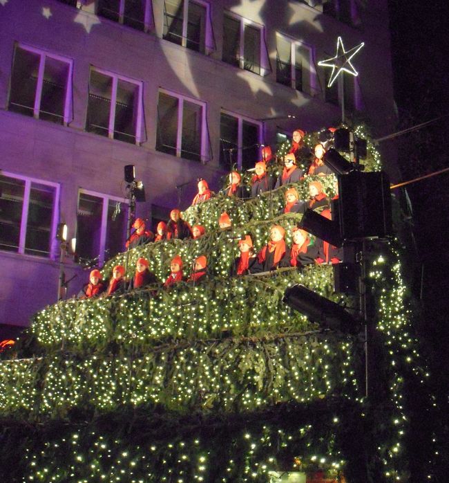 ２０１４年は、日本・スイスの国交１５０周年にあたるので、スイス西部をメインにフランス・アルザス地方とドイツ（フランクフルト）のクリスマスマーケット巡りのツアーに参加しました。<br /><br />写真は、チューリッヒの街中で催されていたクリスマスツリー型の演台で歌う子供達の聖歌隊（シンギング・クリスマスツリー）です。<br /><br /><br />今回巡ったクリスマスマーケット<br />チューリッヒ（駅構内の屋内マーケット）<br />ベルン（スイスの世界遺産）<br />バーゼル（スイス最大規模）<br />コルマール（フランス木組みの町）<br />リクヴィル（ワイン造りの村）<br />ストラスブール（フランス最大規模）<br />フランクフルト（ドイツで最も古いマーケットの一つ）<br /><br />スイス、特にチューリッヒの物価の高さにはビックリしました。<br />クリスマスマーケットでのグリューワインが、ドイツだとカップ込みで５〜６ユーロだったのが、チューリッヒでは中味だけで６フランもしていました。<br />（レートは、１ユーロ＝１５０円、１フラン＝１２５円位）<br />その後、バーゼルからストラスブールへ向かうに従って、物価が下がってきたので安心しました。<br /><br />スイス、フランスともチーズが美味しいので、エメンタールチーズ工場やスーパーで沢山買い込んで帰ってきました。<br /><br />天気には恵まれ、空気の綺麗さと相まって、心地よい旅を体験できました。<br />帰国後、ヨーロッパが大雪に見舞われて交通マヒになっているとのニュースを耳にし、天候に恵まれた旅に感謝です。<br /><br />スイスは、ドイツ語、フランス語、イタリア語、ロマンシュ語が公用語ですが、訪れた土地はドイツ語を話していました。<br />