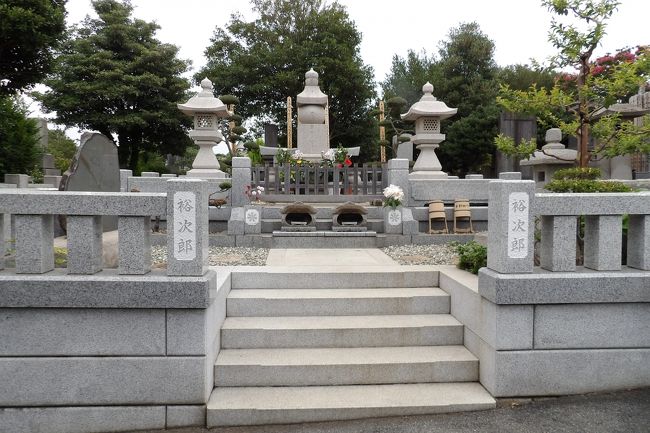 総持寺境内の一番奥に総持寺墓地があり、入口にあるお地蔵さまの横には「石原裕次郎氏の墓処」の案内板が立てられている。この案内板は道なりにずーと続き、「裕ちゃん(石原裕次郎)の墓処」になる。もう墓処が近いことが感じられる。<br /> 墓処の門石柱には「裕次郎」と彫られ、御影石の立派な五輪塔にも凡字の下に「石原裕次郎」と彫られている。墓処の石段横には灰皿が置かれおり、愛煙家だった裕次郎さんのファンや石原軍団にも喫煙者が多いのだろう。<br /> かつて湯川秀樹博士のお墓をお参りしに行った(http://4travel.jp/travelogue/10394519)ときには、「個人情報ですから。」と中々教えてはくれなかった。しかし、教科書にも載っている湯川秀樹博士ともなると、故人となられても、名を知っている人ならお墓を参拝したいと思うのは誰もが持つ日本人の心情であろう。いわんや、それ以上に名の知れた映画スターともなれば、そうはいかないのは容易に想像が付く。<br /> 個人情報云々は分かるが、墓地まで行ったら、故人となられた名の知られた人のお墓であればお参りしたいと思うのは極普通のことであり、それができるように案内版を立てている総持寺側の考えも理解できる。勿論、遺族側の承諾は得てのことではあろうが。<br /> なお、総持寺墓地はとても広いので、自転車で回っている人が何人かいた。墓地には坂があったりして起伏が多いのが一般的であり、自転車に出会ったのは初めてのことで少し戸惑った。<br />(表紙写真は総持寺墓地にある石原裕次郎さんのお墓)