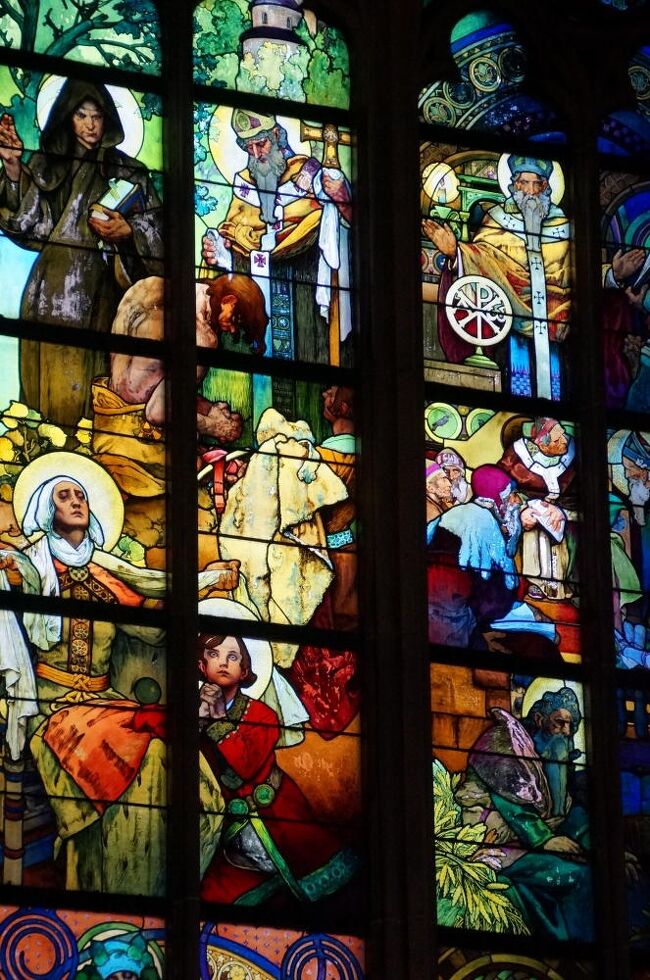 今日は1日チェコ共和国の首都プラハ市内観光。<br /><br />表紙の写真は聖ヴィート大聖堂にあるミュシャのステンドグラス。チェコ民族の歴史をテーマに、ミュシャはこのステンドグラスを作成したが、一番目立つ中央左の人物が聖リュドミラ、そのひざに寄りかかった少年がチェコの守護聖人聖ヴァーツラフなのだが、聖ヴァーツラフのモデルはミュシャの息子だそうだ。<br /><br />なお、ミュシャという呼び方はフランス語で、チェコ語ではムハ。日本ではミュシャの方が一般的なので、以降ミュシャで統一する。<br /><br />2024/03/03　一部修正