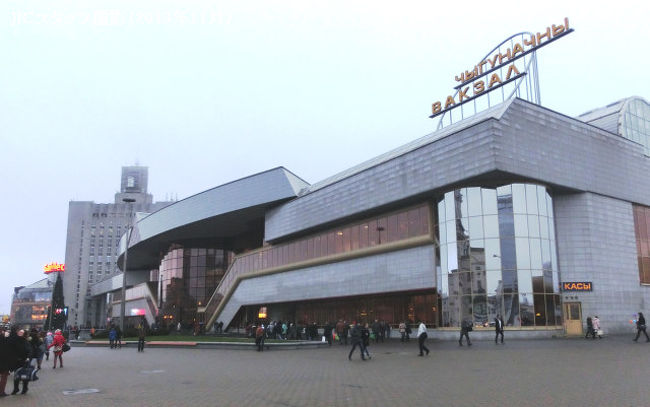 13時34分、13分遅れでロシア最後の停車駅・スモレンスクに到着。遅れを3分だけ取り戻し、13時36分に10分遅れで発車。スモレンスクを出発すると、ベラルーシ側のオルシャまではもう1時間ほどだ。ここで時差調整のため時計を1時間遅らせる。<br /><br />■ベラルーシに入る。国境の緊張感なし<br /><br /> スモレンスクとオルシャの間でロシア・ベラルーシ国境を越えるのだが、ずっと車窓を凝視していたものの最後までどこで国境を越えたのかわからずじまいだった。両国間はEU内と同じような自由往来の協定があるためである。<br /><br /> 入国審査などは一切なく、定刻13時35分(ロシア時間では14時35分)にベラルーシ最初の駅・オルシャに到着した。ここで12分停車する。国境の緊張感はまったく感じない。隣のホームにはミンスク行きのローカル列車が停車している。さっきまでぼんやり立っていたベラルーシの車掌が急に生き生きとして、乗客たちに盛んに話しかけてくる。私にも「外がきれいだからぜひ写真を撮りなさい」と言って、ホームと反対側のドアを開放してくれたりした。確かに、オルシャの駅舎は白壁に赤レンガの装飾がほどこされた美しい建物である。ロシアで見てきた駅舎とは違った印象だ。<br /><br /> 列車はオルシャを出発しミンスクへとひた走る。ベラルーシに入ってから、車窓の景色は明らかに変化した。それまでずっと続いていた白樺やエゾ松の林に変わって、見渡す限り続く田園風景。あちらこちらに見える住宅は、古びてはいるものの、カラフルな一軒家ばかりである。<br /><br />■ミンスク駅<br /><br /> 定刻より1分早く16時05分に列車はミンスク中央駅に到着した。せっかくなので、19分間の停車時間を利用して駅前に出てみる。最近建てられたのであろう近代的な大きな駅舎だ。駅前には、政府関係の施設だろうか、巨大なネオゴシック風の建物がそびえている。当たり前のことだが、駅の案内表示はベラルーシ語、売店の通貨もベラルーシ・ルーブルで、ここはもうロシアではないことが強く印象づけられた。<br /><br /> ぼんやりしていると発車してしまうので、急いで列車に戻った。戻ってみると、隣のコンパートメントにいるロシア人のお婆さんに、別のコンパートメントの若者2人組がしきりとヤミ両替を持ちかけていた。<br /><br /> ミンスク駅で飲み物を買いそびれたので、車掌室にお茶をもらいに行く。紅茶は16ルーブルだが、おつりがないと言われ、一緒に何か買わないかと強く迫られる。勢いに押されて40ルーブルのビスケットをふたたび買うはめに。お湯だけもらうならタダなのだが、湯沸器は車掌室にあり、いちいち車掌に頼まなければならないのは煩わしい。どうやらこの車内販売にはインセンティブがあるようで、その後車掌の1人がカゴいっぱいにグッズを入れてコンパートメントまで売り込みに来た。ロシア鉄道ロゴ入りのボールペン100ルーブル、同じくロゴ入り万能ナイフ450ルーブル。確かにレアものなので、ついお土産にとボールペン5本と万能ナイフを買ってしまう。