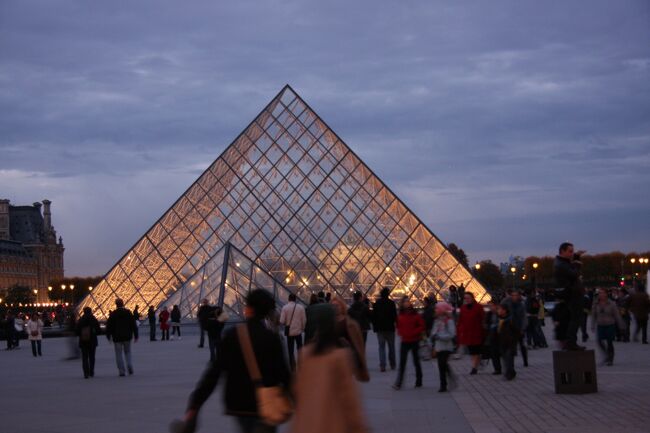 ルーブル広場のガラスのピラミッド　　2011.11.1　17：54<br />Cour Carrée et Pyramide du Louvre<br /><br />4トラの質問の「パリ市内の夜景を自力で周りたい」に回答したところ、たくさんの評価と関心が寄せられたので旅行記として投稿することにしました。<br />クチコミの予定でしたが、写真の枚数と説明文の文字数に制限があるためです。<br />この夜景特集は数回のパリ滞在で撮影した夕方から夜にかけての写真を観光スポットごとにまとめて編集したものです。デジカメ写真は頻繁に撮影時刻を入れました。<br />後半におまけとしてノルマンディー地方の港町オンフルールとブルターニュ地方のモンサンミッシェルの夜景を付しました。<br /><br />■パリの雰囲気が感じられる夜景は夜の暗闇で撮るよりも、日没から1時間後辺りまでの時間帯がお奨めです。暮色（ぼしょく）の街並みに明りが灯った風景の美しさに魅了されて、行くたびにこの時間帯に街へ繰り出せるように時間調整します。夜景というよりも夕景色です。<br />ノートルダム寺院、エッフェル塔、ルーブル広場などもいいですが、サンジェルマンのカフェや裏通りのブティックなどのショーウィンドウの美しさは格別です。<br />またライトアップされたポンヌフやセーヌ河畔を散策しながら水面（みなも）に映る揺れる光を眺めるのは最高の贅沢です。<br /><br />■夕景色の撮影には日没時刻を知っておくことが必要で、クチコミでその方法を紹介済みです。<br />http://4travel.jp/overseas/area/europe/france/mont_st_michael/tips/10177076/<br />http://www.sunrisesunset.com/predefined.asp<br />（検索サイト）<br /><br />■移動はメトロが分りやすいので案内はメトロを基本にします。<br />バスに慣れていて路線図が頭に入っている方はこの旅行記は不要ですね。<br />パリのメトロの治安は、NYとは異なり昼と夜の違いはほとんどないと思います。スリ少女グループの勤務時間はおもに昼間なので、夜が不安と感じるのは乗客が極端に少ない路線・時間帯と思います。なるべく乗客が多い車両に乗り、ドア付近に立ちどまらず奥の席に着くのが安全です。<br />レストランなどの賑わう時間帯は21〜23時で、メトロもほぼ連動しているので夜間乗車を心配し過ぎなくてよいと思います。<br /><br />■3時間夜景個人ツアーの一例（エッフェル塔、ルーブル広場、ノートルダム寺院）<br />ルートはホテル最寄りのカデCadet19：45→Chausee d&#39;Antinで9号線に乗り換えTrocadero20：15→シャイヨー宮広場からエッフェル塔見学・撮影20：45→9号線で戻り、Franklin D.Rooseveltで1号線Palais Royal 21：15→ルーブル中庭の夜景21：30→ポンデザールを渡りセーヌ左岸を歩いてポンヌフの夜景を見ながらノートルダム寺院へ22：00→ノートルダム寺院夜景22：20→シテCiteから4号線で東駅Gare de l&quot;Est乗り換え(又はシャトレChatletから7号線で7駅目の）カデCkdet22：45<br /><br />昼間同じコースを歩いてみると地理感がつかめ、太陽がない夜間でも方角がつかめて安全かつスムーズに撮影できます。<br /><br />■メトロの所要時間は1駅2分、乗り換え10分ですが、パリの2大迷路駅のシャトレとモンパルナスでの乗り換えは避けるのが賢明です。駅名が同じでも実質は異なる複数の路線があり、外国人には慣れるのが大変です。都内でたとえれば赤坂見附・永田町駅や大手町駅です。<br /><br />■メトロは乗車時にホームへの通路にある路線図（駅名表示板）で目指す駅名を確認することが必須です。<br />それを怠って方向を間違うと容易には戻れません。パリには同じホームの左右に異なる方向の電車が止まる駅は基本的に無いので連絡通路で移動しますが、連絡通路が無い駅もあります。その場合は一旦ホーム又は駅の外に出なければなりません。<br />ホームへ入線してきた電車に表示された終点駅名を見て間違いに気づいた場合は、改札内側の赤いボタンを押して駅員を呼び出し、間違いを告げて改札を一旦出てから、新しい切符を駅員からもらって入り直します。<br />素直に対応してくれる男性駅員に出会ったら「ラッキー！」と心の中だけでつぶやきましょう。<br />ここまでできればメトロ検定合格です（笑い）<br /><br />メトロ駅の構内・出口などの写真が載ったサイトを紹介します。<br />パリのメトロの駅の案内サイト（路線、駅構内写真など）<br />http://www.metro2003.com/station/ligne-12/1208.shtml/<br />とても詳しいサイトで、駅を選んで（探して）「この駅のページを見る」を開くと写真が見られます。またスピーカーのマークにカーソルを当てると駅名のフランス語の音声が聞こえます。<br /><br />メトロの乗車券は10枚セット（カルネcarnet）http://www.ratp.fr/fr/ratp/c_21158/ticket-t/<br />、1日券（パリヴィジット）http://paris-travel.amary-amary.com/c_trafic/parisvisite.php/<br />が便利です。<br /><br />■風景人物写真※の構図は、先ず背景の構図（フレーミング）を決め、人物は中央ではない位置に3〜5ｍの距離に、斜め前を向いて、人物の前側の空間が少し広くなるように立つのが自然です。（私のサイト写真参照）<br />広角レンズは遠近感が強くなるので、近めに立つのがお奨めです。<br />背景の被写体（例えば記念碑など）に近づこうとバックするのはお奨めしませんが、証拠写真ならよいでしょう。<br />背景の構図を決めて固定するには三脚が必要で、他人に依頼して気に入った写真を期待するのはしょせん無理です。<br />一眼レフで依頼するには、できれば同じメーカーの一眼レフの所有者が適しています。コンデジのユーザーはファインダーを覗いたことはないので撮り方が分らない人がほとんどです。<br /><br />※フランスの印象派画家の後援者のカイユボットは風景人物画の画家としても知られており、2013年末にブリジストン美術館で特別展「カイユボット展ー都市の印象派」が開催された。<br /><br />■人物を入れた夜景撮影でモードがオート（AUTO,Pなど）の場合、ストロボは人物しか当たらないので背景は暗くなってしまうため、背景がある程度明るい日没前後の時間帯が適しています。エッフェル塔を最初にしたのはそのためです。<br />マニュアル（M)の場合は1/30〜1/125sec程度がよいと思いますがカメラによって異なるので十分試し撮りするとよいでしょう。<br />最近のデジカメは高いISO感度を設定できるので応用が利きます。<br />三脚を使用しない手持ち撮影ではISO　800〜1600程度がよいです。<br /><br />人物は入れずに夜の風景のみの場合はPモードで露出補正量を試しながら撮る場合と、マニュアルで撮る場合がありますが、カメラの各種設定（感度、絞り、S速度、WBなど）を行うのに首から紐で下げたLEDライトが便利（必需品）です。<br /><br />■ムーラン・ルージュMoulin Rougeの赤い風車はパリの夜景を象徴する風景なのでお奨めです。昼間は価値が半減以下？<br />最寄りのメトロ駅は2号線ブランシュBlancheですが、2・12号線のピガール又は2・13号線のプラス・ド・クリシーの中間です（各500ｍ）<br /><br />■夜のピガール周辺を男が1人で歩くと、「シャチョーサン　イイコイルヨ　○○シタイ？」などと声がかかりますが、昔のことで現在はどうかわかりません。どのように対応するかは自己責任で決めればよいですが、余分な現金とクレジットカードは持参しないことが肝要です（パリ警視庁）。<br /><br />■タクシーは基本的にタクシー乗り場で乗りますが、その際ホテルならホテル名と住所をサインペンで書いたメモを渡して、「イッシ　シルブプレ」（ここへ行ってください）が安心でお奨めです。乗るときの挨拶「ボンジュー（昼間）、ボンスワ（夜）」、支払ったときの「メルシー」も大切です。<br /><br />■編集後記<br />この旅行記は個人旅行のためのガイド「パリの街歩き　未来旅行記1,2」の付録として書きました。<br />夜の安全で楽しい街歩きの参考になれば幸いです。<br />内容は随時見直し、追加改訂します。<br /><br />パリは1965年に学生フランス工業視察団http://4travel.jp/travelogue/10753546/<br />の一員として訪仏時に長期滞在して以来何度も訪れていますが、気に入ったエリアは大体決まっていて毎回行くことにしています。「パリの青山」と勝手に呼ぶサンジェルマンで、この夜景特集にも載せました。<br /><br />■撮影<br />CANON EOS40D EF-S17/85(2008以降）<br />CONTAX RX  Vario-SonnarT* 35-70mm F3.4 (2002)<br />Nikon Coolpix5400(2006)<br /><br />夜景の参考旅行記<br />http://4travel.jp/travelogue/10522902　2010ルーブル<br />http://4travel.jp/travelogue/10489821　2008ルーブル<br />http://4travel.jp/travelogue/10485630　2008サンジェルマン<br />http://4travel.jp/travelogue/10645066  2011エッフェル塔・ルーブル<br />http://4travel.jp/travelogue/10468332　2008モンサンミッシェル<br />http://4travel.jp/travelogue/10540734　2002モンパルナス<br /><br />「スリの被害に遭わないための予防策」<br />http://4travel.jp/overseas/area/europe/france-ile_de_france/paris/tips/10176840/<br /><br />「パリの街歩き　未来旅行記1,2」<br />http://4travel.jp/travelogue/10592998<br />http://4travel.jp/travelogue/10596907<br /><br />yamada423　2014.8.26<br /><br />☆お気に入りブログ投票（クリック）お願い★<br />http://blog.with2.net/link.php?1581210<br />