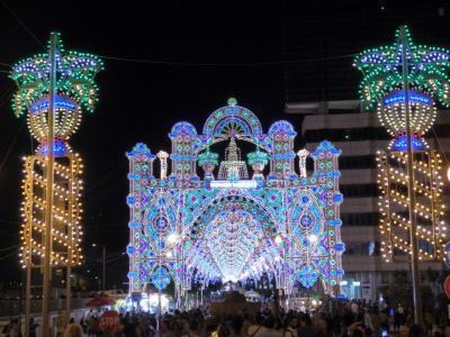 7月9日〜28日の18泊20日、南イタリアへ行きました♪<br />世界遺産の風景、美しい島やビーチ、白い街並み、果てしなく続くオリーブ畑、煌めく海岸、バロック街並み、数多の優雅な城、美味しいグルメを楽しんできました♪<br />訪れたのは、ナポリ、ポンペイ、エルコラーノ、ビエステ、ペスキチ、ヴィーコ・デル・ガルガーノ、トレミティ諸島（サン・ニコラ島+サン・ドミノ島）、ポリニャーノ・ア・マーレ、カステッラーナ・グロッテ、モノポリ、オストゥーニ、チステルニーノ、ロコロトンド、アルベロベッロ、マルティナ・フランカ、チェーリエ・メッサーピカ、ブリンディジ、オーリア、ターラント、フランカヴィッラ・フォンターナ、カロヴィニョ、レッチェ、ガラティーナ、ポルト・チェザーレオ、コリリアーノ・ドトラント、オートラント、レウカ、アレッサーノ、スペッキア、ソレート、ナルド、ガリポリ、トッレ・ア・マーレ、バーリ、カステル・デル・モンテ、アンドリア、トラーニの３７か所へ行きました。<br />宿泊地はナポリ、ビエステ、ポリニャーノ・ア・マーレ、オストゥーニ、レッチェ、オートラント、ガリポリ、バーリの８か所。<br /><br />☆Ｖｏｌ３０３：第１５日目（７月２３日夜）ガリポリ♪<br />当日と翌日の２日間お祭りが行われる。<br />聖母マリアの昇天祭。<br />ホテル「Palazzo del Corso」前のメインストリート「Corso Roma」はお祭り会場。<br />たくさんのルミナリエで輝き、素晴らしい。<br />幻想的で美しい。<br />屋台がたくさんぎっしりで、たくさんの人で賑わう。<br />ガリポリおよびサレント半島の名物が集まり、<br />壮観。<br />レッチェ周辺の名物であるアーモンドキャラメル、<br />ガリポリの名物であるイワシの黄色い酢漬け「Scapece」、<br />サレント半島名物のオリーブ酢漬け、<br />などありとあらゆる物が集まり、<br />サレント半島の伝統料理の博覧会といった趣で、<br />貴重な体験。<br />ウキウキとお祭りに参加して♪