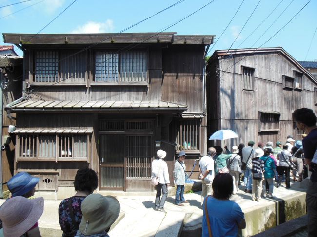 7月1日、三日間の佐渡の旅の最終日、島の最南端に位置する小木地区を訪れた。小木港は江戸時代後期から明治初期にかけて北前船の寄港地として、千石船が盛んに往来して大いに栄えた。この海運業を支えていたのが小木港から少し西寄りの宿根木であり、廻船を所有し、造船や船の修理を行う拠点であった。宿根木の集落は入江の狭い地形に家屋を密集させる独特の街並みが形成された。全国各地から集まった船大工の手によって造り上げられたという。今も当時の面影をそのまま残しており、国の重要伝統的建造物群保存地区に指定されている。この街並みをしばし散策・・・・。