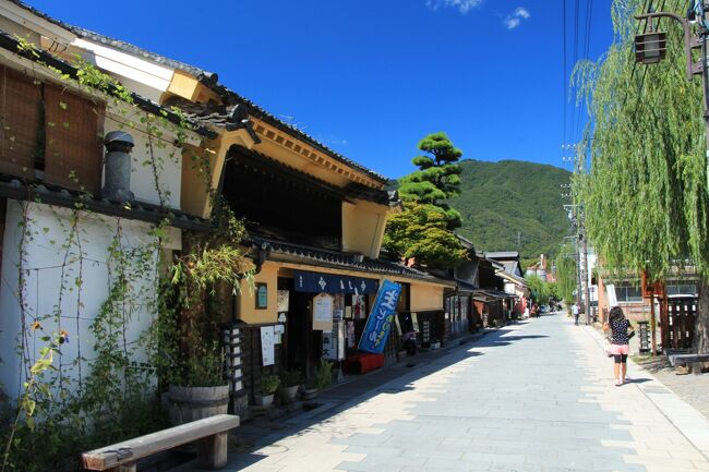 長野県上田市は、真田昌幸が1583年に上田城築城とともに整備した武家屋敷や城下町の伝統を受け継ぐ町で、北国街道の宿場町としての顔も併せ持っています。<br /><br />この北国街道は、上田城址公園の北側を東西に走る国道18号線と矢出沢川を隔てた南側を通っており、矢出沢川から分かれた蛭沢川の東側を南に折れると、石畳の道に伝統的な様式の町家が軒を連ねる、柳町の美しい町並みが現れます。<br /><br />切妻屋根で平入りの町家には、見事な千本格子や袖卯建をあげたものが多く見られ、また、この地方の繭倉にこぞって使われていた、「置き屋根」と呼ばれる二重屋根の架かった土蔵などが柳町の町並みを特徴づけています。<br /><br />宿場町の面影を今に伝える柳町の、美しい町並みが持つ価値に気付き、城下町上田の貴重な文化的財産として保存すべきという機運が高まる中、年々伝統的な町家が失われるのを嘆いていた町の有志の方が、明治時代の初めに呉服屋を営んでいた見事な格子戸のある木造二階建ての商家を改装したカフェや、長年物置代わりとして使用されていた土蔵をレストランに改装するなど、自らが率先して町並みの保全・活用に取り組まれておられます。<br /><br />これに触発された上田市も、総合的かつ計画的な景観形成を目指した「ロマンのまち整備事業」計画を策定、その中で「上田の歴史的町並みと建造物」を重要な景観資源に位置付けるなど、優れた景観形成に努めておられます。