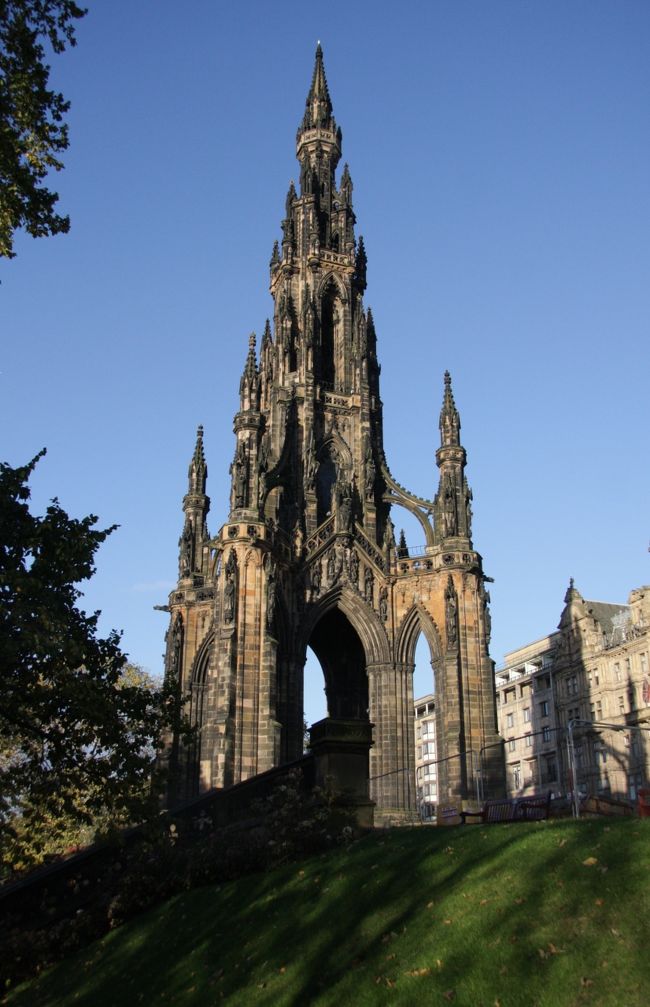 スコット記念塔　2014.10.15　　9：06<br />Scott Monument<br /><br />写真旅行記　Travel Photo Essay<br />2014.10.13(月）〜10.27（月）15日間<br /><br />第4回　エジンバラの街歩き<br />No.4　Town walk in Edinburgh<br />この日はとても長い一日で、旅行記も午前・午後・夜の3編となる。<br /><br />10月15日（水）午前　快晴　日の出7：43　日没18：14<br />この日のエジンバラの気温は13/2℃ （東京の12月初〜中旬並）<br /><br />エジンバラ到着3日目のこの日が市内観光の初日となった。<br />2時と4時に目覚めてしまったが、その後は7時少し前まで眠れた。<br />今日はツアーではないので朝食は8時ごろで、今朝はフルーツ・サラダも食べたが新鮮で美味しかった。<br />午前中は新市街を観ることにして、最初はホテル前のウェーヴァリー橋を渡って新市街へ向かった。この橋の下は駅のホームであるが、橋の欄干は人の背丈ほど（1.8ｍほど）の高さの壁で外（下）は見えないので気付かない。橋の上歩道の自販機でエジンバラ市街地図CITYSCAPEを£2で買ったら同じものが2部出てきた。<br />線路は旧市街と新市街を分ける谷底を走っており、線路の両側は公園になっている。駅に近い側はEast Princes Street Gardensで西側のエジンバラ城北側がWest Princes  Street Gardensである。<br />公園に入ってみるとリスが寄ってきて、与えたエサのビスケットを両手で持って器用に食べていた。カッワイー！<br />公園に沿った新市街のメイン・ストリート沿いに建つスコットランドを代表する作家ウォルター・スコットSir Walter Scottを讃える記念塔は高さ60ｍもあり、遠くからでもよく見える立派なものだ。<br /><br />記念等の前の道路を北に向かうと、右側の広いセント・アンドリュー広場Saint Andrew Squareに建つ高いモニュメントMelville Monumentが目に入る。広場には洒落たカフェなどもあるが朝食の後なので素通りだ。<br />　<br />広い電車通りを挟んで広場の向かいにはロイヤル・スコットランド銀行の立派な建物があり、9時半の開店時刻を待って中へ入ってみるとガラス窓付きのドームのある広々とした空間に驚き目を見張った。<br />まるで何かのようだと言いたいが、比べるものが頭に浮かばない。<br />東京駅北口ドームの10倍の大きさの空間とでも表現するしかないが、豪華さと美しさは比類無しだ。<br /><br />行内には第一次世界大戦で亡くなった銀行のスタッフの名前を書いた記念碑（レリーフ）なども掲げられている。<br /><br />ウェーヴァリー駅前の観光案内所で切手を買ったりしながら、一旦ホテルへ戻り、歩数計を着けてから国立スコットランド美術館へ向かった。<br />美術館はあまり時間を割けないのでちょっと覗いただけで印象が薄いのが正直なところだ。<br /><br />美術館からエジンバラ城へ向かう長い石段で出会った家族連れの写真を撮ったが、声をかけたとき「写真を撮ってもらえるなんて、エジンバラに住んでいる者にとっては嬉しいわ」と言われ、市民の素朴さに驚いた。この経験が午後のエジンバラ城での家族写真の撮影に役立つことになる。（第5回掲載）<br /><br />旅行記に記載のポンド／円レートは180円としたが、外貨購入の189円とクレジットカード精算の172円の中間値です。<br /><br />■旅行計画要約（毎回掲載します）　<br />Abstract of the trip to Scotland and France<br />http://4travel.jp/travelogue/10935919<br /><br />イギリスは自動車会社Ｈの研究所勤務時に、1980年代初頭から90年代半ばまでローバーとの共同開発を含むjoint projectの機会に何度となく出張し、イギリス人から生きた英語を学んできたので、私にとっては学生時代に交流があったフランスとならび特別な親近感を抱く外国。<br /><br />しかしいつしか高齢となり、いつまで海外旅行ができるか分らなくなったため、一度も行ったことのないイングランドと地続きのスコットランドへ行ってみたくなり、半年ほど前に今年の旅行先に決めた。<br />先日のスコットランドの独立の是非を問う国民投票が公示される以前のことだ。<br />体質の関係で日本酒は全くダメだが、ウィスキーは好きで、最近は飲む機会が少ないが、昔はオールドパーのボトルキープができた古き良き時代もあった。水で割ってはせっかくの香りが薄まるのでロックがよい。<br />イギリスへ出張を繰り返していた80年代に、イギリス人に緑の三角形の瓶で知られたシングルモルト・ウィスキーの草分けグレンフィディックGlenfiddich（現在はサントリーが輸入・販売）を土産に奨められたこともあった。<br /><br />スコットランドからの帰りにヨークおよびハワースへ立ち寄るのも大きな目的。<br />ヨークは鉄道好きには聖地のような国立鉄道博物館がヨーク駅に隣接している。世界で初めて時速200Kmを超えた蒸気機関車マラード号を始め機関車103両、客車176両、日本の新幹線もあるそうだ。（ブルーガイド・イギリスによる）<br />ヨーク大聖堂や2000年の歴史を刻む城壁や城門も楽しみだ。<br /><br />「嵐が丘」を書いたエミリー、「ジェーン・エア」のシャーロッテ、「アグネス・グレイ」のアン（あまり知られていない）の3姉妹の生まれ育った荒野の中の小さな村で、シェークスピアが生まれたストラットフォード・アポン・エイボンと並ぶ「英国文学の聖地」ハワースは死ぬ前に訪れなくてはならない場所と思っていた。ヨークもハワースも実現できたのでいつでも死ねる。（笑い）<br /><br />後半のフランス訪問については、<br />今年4月に1964年の東京オリンピックの直前の8月に日仏学生交流プログラムで来日したフランスの学生たち（3つの大学の内の1つ）が50年ぶりに再来日することになり、2日間の都内見学の計画づくりと案内に奔走した。<br />彼らがその後鎌倉・箱根・京都・広島・奈良・大阪を回り、帰国後のメールのやり取りでスコットランド旅行の計画を伝えたところ、その帰りにぜひフランスにも足を延ばして再会したいと言われ、誘いに乗ることになった。（7月）<br />リヨン、エクサンプロヴァンス、パリの3都市だが、いずれのお宅も部屋はたくさんあるのでホテルの手配は要らないと言ってくれているので助かる。<br />4月の受け入れ時にはコーディネーターを務めたので、奥様方を含め16人のメンバー全員と顔のつながりができているため、とても楽しみにしている。<br /><br />撮影　CANON EOS40D EF-S17/85,EF-S10/22<br />PowerShot A2300<br /><br />スコットランド・フランスの旅2014　<br />第1回　東京からエジンバラまで　　<br />http://4travel.jp/travelogue/10948376<br />第2回　スコットランドの自然探訪<br />　http://4travel.jp/travelogue/10949966<br />第3回　スコッチウィスキー蒸留所ツアー<br />http://4travel.jp/travelogue/10951228<br /><br /><br />お気に入りブログ投票（クリック）お願い<br />http://blog.with2.net/link.php?1581210<br /><br />