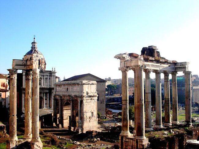 晩秋のイタリア旅行は後半に移り、その最初が待望のローマ。<br /><br />ローマはシエナの広場で見上げた狼の乳で育てられた双子の兄弟の兄ロムルスが、18歳にして初代王となり、建国をしたので国の名もローマとなったと云う。<br /><br />不思議なことに、3000年も昔の話だが、その建国日が紀元前753年4月21日と日にちまで判っているらしい。<br /><br />そこで気になるのがなぜ双子の兄弟は狼の乳を飲んでいるのか、その双子がなぜ兄だけがローマの名の起源となったのか。<br /><br />小川TD のローマ建国物語はギリシャ神話のトロイの美女ヘレンを巡るトロイ戦争に始まる。<br /><br />ギリシャの木馬作戦で知られるトロイ戦争で敗れ、逃げ延びたトロイ側の一族がいた。<br /><br />その一族の兄弟同士の争いで、殺された兄王の娘レア・シルウィアは、子孫の反逆を恐れた父の弟アムーリウスにより、巫女に出さされる。<br /><br />巫女は30年努めなければ結婚できない掟で、シルウィアに子孫が出来ないようにと意図したことによる。<br /><br />しかしながらシルウィアは軍神マルスの子を身籠ってしまう。<br /><br />それを知ったアムーリウスは生まれた双子をテレヴェ川に流す。<br /><br />しかし双子は運よく人里離れた村に漂着し、ここで山から出て来た雌狼の乳で生き延びる。<br /><br />この双子の名が後にローマの街の礎を建てたロムルスとレムス。<br /><br />しかしこの双子の兄弟も、ローマ建設の考えの違いから仲たがいし、レムスは兄に殺害され、遺された二人の子供がシエナに逃れる。<br /><br />兄ロムルスは紀元前753年4月21日、ローマ初代の王となる。<br /><br />ローマ市の中心に建つ、ローマのランドマーク・白亜のヴィットリアーノの裏（東側）は、古代ローマの中心カンピドーリオ広場。<br /><br />カンピドーリオ広場から真下に広がるフォロ・ロマーノを最初に目にした。<br /><br />ロムルス初代王以来古代ローマの政治と人民の生活の中心であり、歓喜と悲哀が織りなす歴史が幾重にも滲む場所である。<br /><br /><br />我々が目にするフォロ・ロマーノは、かのジュリアス・シーザー（ガイウス・ユリウス・カエサル）が整備した姿だと云う。<br /><br />そしてそのシーザーも、親代わりに育てたブルータスによってここで暗殺される。<br /><br />「ブルータス、お前もか！」<br /><br />フォロ・ロマーノのセンター道路・聖なる道（Via・Sacra)を歩くと、歴史を刻んだ人々の怨念が、周囲に次から次と舞い出ずる感じに襲われ、思わず襟を正す。<br /><br />シーザーのバリシカの廃墟のとなった岩の上には、今日も生花が供えられていた。<br /><br />フォロ・ロマーノは10年後再び訪れている。しかし聖なる道を歩いたのはこの旅だけであった。<br /><br />＊参考<br />第２部ヴァチカンを飾る、４人の天才を巡るローマ美術散歩25カンピドーリオ広場から望むフォロ・ロマーノ眺望<br />http://4travel.jp/travelogue/10801290