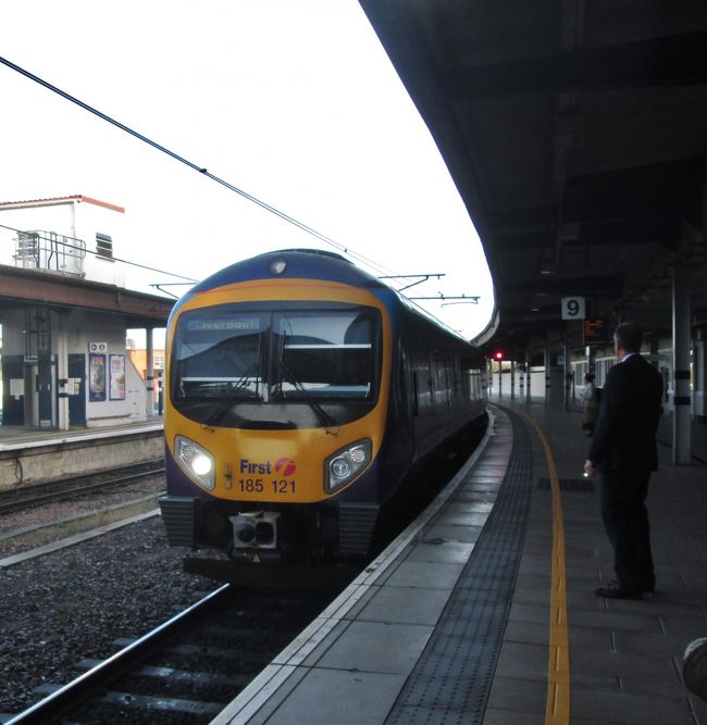 ヨーク発リヴァプール行きの列車（リーズで乗換）2014.10.17　9：19<br />Train for Liverpool to change in Leeds<br /><br />スコットランド・フランスの旅2014<br />写真旅行記　Travel Photo Essay<br />2014.10.13(月）?10.27（月）15日間<br />スコットランド・フランスの旅2014<br /><br />第9回　ヨークからハワースへ<br />From York to Haworth<br />10月17日（金)16℃<br />ヨークのホテルへスーツケースを預け、ハワースへの1泊旅行に出かけた。<br />4時過ぎに目覚め、お茶を入れるために湯沸かしを用意していたらベッドにおいた携帯が光ったので手に取るとＡさんからで、忘年会出席の問い合わせだった。docomoの海外サービスを利用しているので、何かあっても安心感がある。紅茶とクッキーで暫定朝食。<br /><br />朝食は7：30からなので、そのまえにクッキーを持って前の川のカモとアヒル達に撒いて写真を撮った。<br />早朝の川べりの静かな雰囲気は非日常的で、旅先の思い出にしっかりと刻まれるようだ。<br /><br />朝食はフル・イングリッシュ・ブレックファストで、ソーセージ（イギリスの粉っぽいヤツ）、焼きベーコン、スクランブル・エッグ、茹でマッシュルーム、煮トマト、煮豆、トースト、クロワッサン、ジャム、バター、フルーツ、ヨーグルト、各種ジュース、ミルク２種類（一つはfull fat milk)、紅茶、コーヒー。すべてを食べたわけではない。<br /><br />当初の予定の列車は8：15だが早すぎるので１時間遅らせた。<br />朝食を済ませて一休みし、チェックアウトでは支払い済みと言われたのでスーツケースの1日保管を頼んだ。＜Yoji YAMADA collect 10/18＞と書いたシールを貼って、受付カウンター後ろの壁際に置いてくれた。<br /><br />ブリッジ・ストリートBRIDGE STから駅に向かった。<br />ちょうど通勤・通学時間帯のようで、バスのほかに自転車でリュック姿も多く見かけた。中には2台の自転車を縦に連結したほどの長さで、ペダルが3か所の3人乗り自転車もある。<br />ミックルゲート(城門）MICKLEGATEから城壁へ上がってみると内側、外側のそれぞれ違った景色が見えて面白かった。狭い通路の大きな敷石は雨上がりのようにしっとり濡れており、イギリス特有の西岸海洋性気候による湿気の多さを感じることができる。<br />ちなみにイギリスの牧草地は冬になると緑が濃くなり、初めて12月に小型機で上空から見たときに、緑に白い点が羊の群れと知った。<br /><br />ハワースへ行くにはキースリーKEIGHLEYまで列車で、そこからバスに乗り換えることになるのだが、ヨークからキースリー直通がなくリーズ乗換となる。キースリー行きの列車が何番線から出るのか分らない（終点ではないので）ので駅員に尋ねたらスマホで調べてくれた。<br />SKIPTON行き5番線といわれたが、直前に6番線に変更になったようで（放送）、他の乗客について行って事なきを得た。<br />車内でSKIPTON TRAINと放送していたので地域鉄道会社のようだ。<br />乗り込んだ列車の座席の80％以上は予約カードが挟んであったので、無い場所を探して座った。<br />列車運行記録（10.17）<br />YORK 9：18→LEEDS 9:42　乗換<br />LEEDS 9:56→Shipley 10:09→Saltaire(World Helitage)10:12→Bingley 10:17→Crossflatts →Keighley 10:24着<br />料金は現地の前日窓口購入で往復20.9ポンド（￥3760）オンラインと同額<br /><br />キースリーのバス・ステーションは案内地図によると500ｍほど離れていたが、地元の人に教えてもらい、どうにか迷わずに行けた。<br />10：45発の665番バスの車内で地元のご婦人がハワースへ行くのかと訊いてくれ、ブロンテ・ミュージアムと伝えたら降りる場所を教えてくれた。<br />見知らぬ土地でのこのような親切は何よりもありがたく嬉しいものだ。<br />最寄りのバス停はHAWORTH駅前を通過してから3分ほどだった。<br /><br />ミュージアムの位置は観光案内所iで訊いて分ったので、とりあえず荷物をホテルへ置こうとしたが、郵便局で教えてもらったホテルWILSONSへ行ってみるとチェックインは3時からで閉まっていた。スーツケース持参しなくて正解だった。<br /><br />■旅行計画要約（毎回掲載します）　<br />Abstract of the trip to Scotland and France<br />http://4travel.jp/travelogue/10935919<br /><br />イギリスは自動車会社Ｈの研究所勤務時に、1980年代初頭から90年代半ばまでローバーとの共同開発を含むjoint businessの機会に何度となく出張し、イギリス人から生きた英語を学んできたので、私にとっては学生時代に交流があったフランスとならび特別な親近感を抱く外国。<br /><br />しかしいつしか高齢となり、いつまで海外旅行ができるか分らなくなったため、一度も行ったことのないイングランドと地続きのスコットランドへ行ってみたくなり、半年ほど前に今年の旅行先に決めた。<br />先日のスコットランドの独立の是非を問う国民投票が公示される以前のことだ。<br />体質の関係で日本酒は全くダメだが、ウィスキーは好きで、最近は飲む機会が少ないが、昔はオールドパーのボトルキープができた古き良き時代もあった。水で割ってはせっかくの香りが薄まるのでロックがよい。<br />イギリスへ出張を繰り返していた80年代に、イギリス人に緑の三角形の瓶で知られたシングルモルト・ウィスキーの草分けグレンフィディックGlenfiddich（現在はサントリーが輸入・販売）を土産に奨められたこともあった。<br /><br />スコットランドからの帰りにヨークおよびハワースへ立ち寄るのも大きな目的。<br />ヨークは鉄道好きには聖地のような国立鉄道博物館がヨーク駅に隣接している。世界で初めて時速200Kmを超えた蒸気機関車マラード号を始め機関車103両、客車176両、日本の新幹線もあるそうだ。（ブルーガイド・イギリスによる）<br />ヨーク大聖堂や2000年の歴史を刻む城壁や城門も楽しみだ。<br /><br />「嵐が丘」を書いたエミリー、「ジェーン・エア」のシャーロッテ、「アグネス・グレイ」のアン（あまり知られていない）の3姉妹の生まれ育った荒野の中の小さな村で、シェークスピアが生まれたストラットフォード・アポン・エイボンと並ぶ「英国文学の聖地」ハワースは死ぬ前に訪れなくてはならない場所と思っていた。<br />私は女性ではないが、「ジェーン・エア」のあの性格（向上心・質実・努力・情熱・美的感覚・・・）に共感し、自分の人格形成に多くの示唆を与えてくれて何度も読んだ小説の生まれた自然背景に少しでも触れてみたい気持ちを生涯持ち続けてきたが、この歳になってようやく実現できそうで嬉しい気持ちでいっぱいだ。<br /><br />後半のフランス訪問については、<br />今年4月に1964年の東京オリンピックの直前の8月に日仏学生交流プログラムで来日したフランスの学生たち（3つの大学の内の1つ）が50年ぶりに再来日することになり、2日間の都内見学の計画づくりと案内に奔走した。<br />彼らがその後鎌倉・箱根・京都・広島・奈良・大阪を回り、帰国後のメールのやり取りでスコットランド旅行の計画を伝えたところ、その帰りにぜひフランスにも足を延ばして再会したいと言われ、誘いに乗ることになった。（7月）<br />リヨン、エクサンプロヴァンス、パリの3都市だが、いずれのお宅も部屋はたくさんあるのでホテルの手配は要らないと言ってくれているので助かる。<br />4月の受け入れ時にはコーディネーターを務めたので、奥様方を含め16人のメンバー全員と顔のつながりができているため、とても楽しみにしている。<br /><br />撮影　CANON EOS40D EF-S17/85<br />PowerShot A2300<br /><br />スコットランド・フランスの旅2014　1.東京からエジンバラまで　　http://4travel.jp/travelogue/10948376<br />スコットランド・フランスの旅2014 2.スコットランドの自然探訪<br />　http://4travel.jp/travelogue/10949966<br />スコットランド・フランスの旅2014　3.スコッチウィスキー蒸留所ツアーhttp://4travel.jp/travelogue/10951228<br />スコットランド・フランスの旅2014　4.エジンバラの街歩き<br />http://4travel.jp/travelogue/10953587<br />スコットランド・フランスの旅2014  5.エジンバラ城<br />http://4travel.jp/travelogue/10958956<br />スコットランド・フランスの旅2014　6.ロイヤル・マイルとスコティッシュ・ダンス　<br />http://4travel.jp/travelogue/10959995<br />スコットランド・フランスの旅2014　7.ヨークの国立鉄道博物館<br />http://4travel.jp/travelogue/10961797<br />スコットランド・フランスの旅2014  8.ヨーク大聖堂と街歩き<br />http://4travel.jp/travelogue/10961819<br /><br />お気に入りブログ投票（クリック）お願い<br />http://blog.with2.net/link.php?1581210<br /><br />