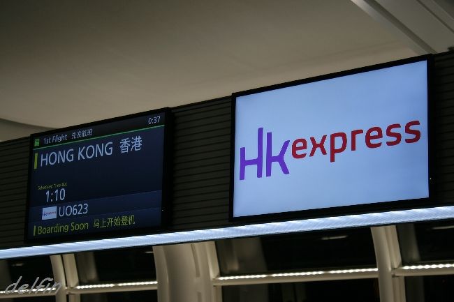 日曜深夜、月曜に日付が変わる時間帯の羽田空港です。<br /><br />２０１５年の動き出しは香港、「毎月ソウル」は今月お休み。<br />『HK Express』の就航記念プロモーション・のチケットを半年ぐらい前に購入していたので、<br />そいつに挑みます。<br /><br />旅に出るのに「挑みます」ってのはヘンですが、<br />こいつは羽田を１：１０に飛び立ち、香港５：４０に到着、<br />帰国便は０：０５に羽田に着くという、さすがＬＣＣらしいタイム・テーブル・アレンジなのです。<br />　<br />なので日曜の夜から出かけ、翌週の日曜を５分過ぎたところで帰国するという、<br />日程的には８日を費やしながら、両日曜を除いた正味６日の旅路。<br />　<br />まあプロモーションで総額２万円だったので「挑んでみる」かなあ、と。<br />（空港使用料、サーチャージ込みの安売りです）<br />仕事のスケジュール的にもＮＦＬのプレイオフも終わり、<br />来週のスーパーボウルまでに帰ってくるって作戦でさあ、ダンナ。<br /><br />Ｐａｒｔ１のブログに何度か記してますが、<br />香港はこのところマカオや深セン、珠海への乗り継ぎにしか使ってなかったので、<br />ゆっくり街に出てなかったのですね、<br />空港からフェリーとか、地下鉄から空港鉄道とかぐらいで。<br /><br />調べたら２００５年から街を歩いてない。<br />ＵＡが香港路線から撤退した、というのも大きな要因です。<br />http://delfin.blog.so-net.ne.jp/2011-01-19<br />　（香港経由）<br />http://delfin.blog.so-net.ne.jp/2008-05-24<br />　（香港滞在記）<br /><br />２２時過ぎに赤い電車に乗って羽田空港へ。<br /><br />暗くなってからキャスターバッグ引きずって出かける、ってのはヘンな感じ。<br />どうも羽田はプロモーション・チケットで使うことが多いので、<br />ヘンな時間帯に訪れることが多いな。<br />http://delfin.blog.so-net.ne.jp/2011-01-26<br />　　羽田ＫＥ早朝便<br /><br />すっかり２４時間化されている羽田空港は深夜だというのに人が多い。<br />小さいながらも深夜の安い発着枠を生かし、各社こぞって便を増やしているので、（写真１）<br />アチラコチラに出かける日本人旅行者とアジアからの日本に来た旅行者が入り混じってます。<br /><br />チェックインするとほぼ満席らしく、３?３のシートの真ん中しか空いてないという悲しいお知らせ。<br /><br />プロモーションだったので事前のシート・リクエスト（有料）なしの最安値に挑んだので、仕方なし。<br />安いチケットはこういう割り当てが回ってくるので、みなさんご注意を。<br /><br />「旅行」に関しては「安くていいもの」ってのはないと思っていいですよ。<br />「ホテル」にしろ、「フライト」にしろ、「ツアー」にしろ、<br />『安いものには理由（ワケ）がある』ということです。<br /><br />抗っても仕方なので承服して、真ん中席もらいましたが、「６Ｅ」と意外と前方席でちょとラッキー。<br /><br />UO623便は新車、じゃないや、A320の新機材、全席エコノミーのシート・アレンジ。<br />座席は合成皮革、おそらく掃除がラクなのでコレなのでしょうが、清潔感あっていいです。<br />シート・ピッチは１８１ｃｍの体格でキッチリヒザが当たるぐらい。<br />決して広くはないですが、それほど狭い印象でもなく。<br /><br />あ、搭乗はバスでなく、「ボーディング・ブリッジ」からでした、香港ではバスに乗せられたけど。<br /><br /><br /><br />機内食・飲み物は販売制、カップ麺が＄２０＝￥３００ほど、飲み物＄１０ほど、ＬＣＣの相場かな。<br />こちらは乗る前に夜食のオニギリを頬張り、お茶を買って乗ったので、それらは必要なし。<br />深夜便ということもあり、飲み水などを配ることもなく、明かりは消され、みな爆睡モード。<br />そのあたり香港人は手馴れたもの、あるいはリピーターかもしれないですね。<br /><br />こちらも負けずに土曜、日曜とがっちりテニスして、６時間後に空港にいるという態勢で、<br />しっかり疲れて来たので、文庫本を読んでいたらすぐに熟睡。<br />ロング・フライトのヨーロッパ便だと徹夜明けで行って爆睡する作戦をよくとっていたっけ。<br /><br />４時間半のフライトを経て、定刻通り５：４０着、叩き起こされた乗客はボー然と入国に向かうわけです。<br /><br />ここで入国せず、制限区域ロビーのベンチでトランジット客に混じり、仮眠することに。<br />宿のチェック・インは１４時からだし、<br />１時間弱で街に出てもコーヒー・ショップぐらいしかやってないんだし、<br />両替してないし、眠いんだし、ロビーはあったかいんだし。<br /><br />どこでも寝られる特技を生かし、９時まで仮眠、いや熟睡。<br />入国前の制限区域なので、荷物の心配も少ないんだし。（もういいって）<br /><br /><br />空港からはバスを拾い、１時間弱で香港島のコーズウェイ・ベイへ。<br /><br />今回、とても困ったのが宿、最近の香港はどう調べても「安宿」が安くない、<br />ドミトリーでも￥３０００ぐらいするのが腹立たしいというかばからしいというか。<br /><br />趣旨変えして、コーズウェイ・ベイの一泊￥５０００ほどの安ホテルのシングルをブッキング。<br />そこに荷物だけ置いてもらい、ブランチでも取りに行くかと思ったら、<br />「シングルの部屋、空いているから入る？」とのマネージャーのお言葉。<br /><br />「わお、トーチェ（多謝）」と言いながら、そのままベッドに倒れこみ、三度目の熟睡って、おい。<br /><br /><br />つづきは・・・<br />http://delfin2.blog.so-net.ne.jp/2015-01-31