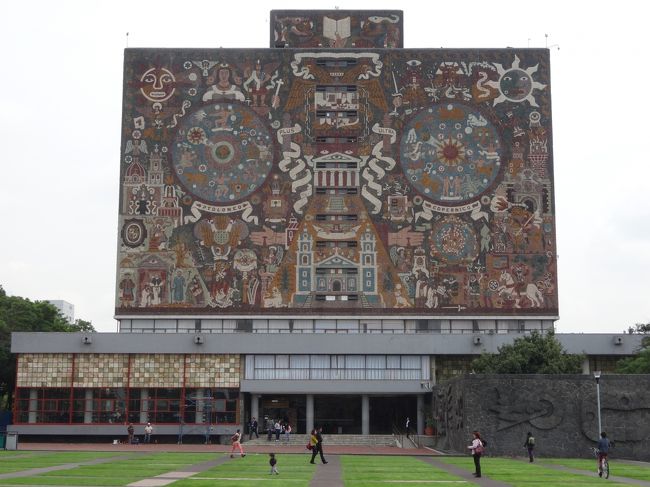 「メキシコ国立自治大学」は「メキシコシティ南部のコヨアカン地区」にある「建築家マリオ・パニとエンリケ・デル・モラル」によって設計された「計４０の学部・研究所、文化センター、生態系の保全区域、中央図書館、博物館」などが設置されている「大学キャンパス」です。<br /><br />「２００７年」に「メキシコ国立自治大学の大学都市の中央キャンパス」として「世界遺産」に登録されています。<br /><br />写真は「にアステカ人とスペイン人をモチーフにした絵」で「壁画としては世界最大」の「中央図書館」です。