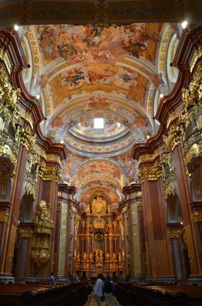 6月20日土曜日、今年の2回目のウィーン訪問には特別な目的があった。それはマリス・ヤンソンス指揮、ウィーンフィルの演奏会を聴くことだ。2ヶ月前から完売しており、当日15:30開演の1時間前に残券のみを売り出す、ということなので、本番当日に早めに並ぶしか入手方法はない。従ってこの日の13:30ころウィーンフィルチケットオフィスに並ぶことにして、午前中にオーストリアの6番目の世界遺産「ヴァッハウ渓谷の文化的景観」を訪れることにした。<br /><br />ヴァッハウ渓谷というのはドナウ川に沿って36キロに及ぶ広大なエリアを含む。時間があればザンクト・ペルテンまでドナウ川遊覧船に乗る方法がベストであるが、とても時間的余裕はないので、まず早朝にウィーンを発ってメルク駅まで行き、メルク修道院が開場する9時までの数時間にこの渓谷を可能な限り散策することにした。<br /><br />6時過ぎにウィーン中央駅を出発するレールジェットでザンクト・ペルテンまで行き、ローカル列車に乗り換えてメルク駅に7時半過ぎに到着、駅から徒歩で15分ほど丘の上にメルク修道院を眺めながら、旧市街を通り抜けるとドナウ河畔に着く。船着場があって遊覧船に乗ろうとする人々を横目に見ていわゆるヴァッハウ渓谷と呼ばれるほんの一部を撮影して歩いた。当然ライン川の渓谷と比較してしまうが、ライン川が大きくカーブし、両岸の岩壁が切り立ってローレライのような高低差のある絶景を呈しているのに対し、この近くを流れるドナウ川はカーブが少なく、既に川幅が広く大河の様相を示し、両岸も高低差がさほどなく、なだらかで女性的な景観だ。<br /><br />そして何と言ってもヴァッハウ渓谷のハイライトはメルク修道院である。この修道院の設立は1089年、バーベンベルク家のオーストリア辺境伯レオポルト2世により、ランバッハ修道院出身のベネディクト会修道士に城の１つが寄贈されたことに始まる。修道院の図書館はまもなく規模を広げ、幅広い写本収集で知られるようになり、また写本の生産が行われた。そして最も見応えのあるのはバロック建築の修道院、1702年から1736年にかけて、ヤコブ・ブランタウアーの設計により建設、またヨハン・ミヒャエル・ロットマイヤが修道院の教会に描いたフレスコ画と、中世の手描き原稿が無数に納められた図書室である。圧巻なのは教会内部の精緻な装飾だ。これは何時間見ていても飽きない。これほど見事な教会の内装で比較できるのは、ノイシュヴァンシュタイン城の近くのロココ様式の装飾で名高いヴィース教会と、バロック建築の傑作、スイスのザンクト・ガレンの教会が思い出される。<br /><br />その後のメルク修道院は、神聖ローマ皇帝ヨーゼフ2世が1780年から1790年にかけて修道院を接収、解散させた時期をかろうじて凌ぎ、ナポレオン戦争、次いで1938年のナチスによるオーストリア併合「アンシュルス」期には修道院の大部分を国家に接収された。 第二次世界大戦では大きな被害を免れ、戦後学校は修道院に戻され、現在も修道院として機能している。<br /><br />メルク修道院から急ぎ足で駅に戻り、ウィーン中央駅行きの予定の列車よりも1時間ほど早く到着し、1本早いウィーン西駅行きの列車に乗ることにした。途中ザンクト・ペルテンで乗換え時間が多少あるため、旧市街まで足を伸ばした。歩行者天国のクレムサー・ガッセにはユーゲント・シュティールのファサードを持つ美しい街並みが続き、市庁舎、ドーム教会などを撮影して歩いた。<br /><br />懐かしいウィーン西駅に到着、構内は2011年に改装されており、新しい店舗が並んで以前の薄暗いイメージも今は昔である。そしていよいよウィーンフィルのチケットオフィスに向かう。ヤンソンスのチケットははたして手に入るだろうか？