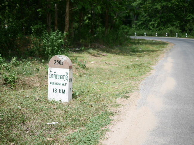 ルアンプラバーンの街からKuang Siの滝まで約30Km。<br /><br />レンタルバイクでツーリングに出かけた。<br /><br />道は、ルアンプラバーンの街を出れば、そこからほぼ一本道。<br /><br />バイクの距離計は動かないが、一里塚、いえ、マイルストーンがあるので安心です。<br /><br />