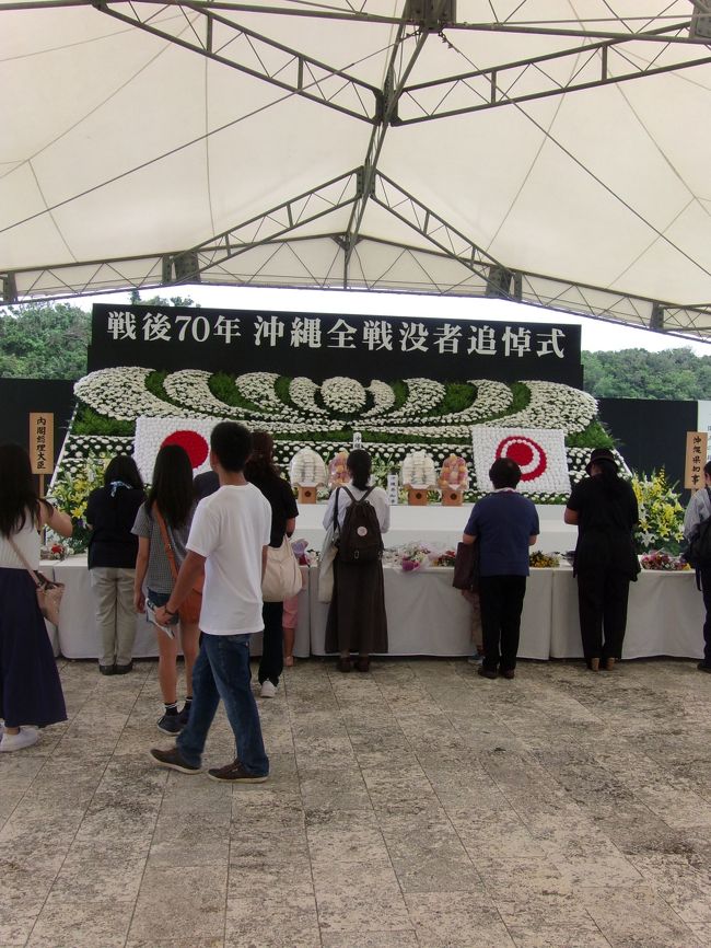 ≪戦後70年沖縄全全戦没者追悼式典　祭壇の様子≫<br /><br />なにも考えずにただ南の島へとやって来て、ぼ～っと時間を過ごすことに始まった沖縄の旅ですが、いつの間にか11回目になりました。中でも一昨年9月に〝初石垣〟を経験してからは実に1年9ヶ月の間に7回目になります。<br /><br />いつもは〝日にち重視パターン〟というより〝値段重視〟なので、LCCのバーゲンを見つけては手配した後に休みを取るパターンでした。しかし今回は初めて〝日にち重視〟でまず〝宿手配〟から始まった沖縄の旅、目的はかねてより一度参列してみたいと思っていた6月23日の〝沖縄慰霊の日〟に沖縄県営平和祈念公園で執り行われる〝戦没者追悼式典〟、そして前日夜から始まる〝沖縄の最も長い一日〟に触れることにありました。<br /><br />今回はいつもの〝沖縄時間〟を過ごすこととは目的が異なるため、手配状況によっては旅行会社のフリープランを使うことも考えていました。しかしたまたま1月にJet Starのバーゲンにて〝この日〟を含む日程でチケットが手配できたため、結局プラン二ングの段階では従来となんら変わらないものにはなっています。ただ内容がかなり〝違った〟ものになるため、展開を変えています。<br /><br />この章〝≪2015.Jun≫あみんちゅ歴史に触れる旅沖縄その壹之③～戦後70年沖縄全戦没者追悼式参列：3日目～〟では、戦後70年沖縄全戦没者追悼式参列に始まり〝沖縄のもっとも長い一日〟を過ごしたことについて書いています。<br /><br />【2015年6月23日火曜日】<br />糸満市大度　10：26<br />沖縄晴明の丘公園　10：48　3.6km<br />　　　　　　　　　11：00<br />沖縄県営平和祈念公園　11：20<br /><br />〝戦後70年沖縄全戦没者追悼式典〟参列。<br />　　11：50～12：59<br /><br />沖縄県営平和記念公園14：41（並び始めは14：00）<br />沖縄晴明の丘公園　14：45<br />　　　　　　　　　15：09<br />沖縄師範健児之塔　15：13　4.7km<br />　　　　　　　　　15：44<br />沖縄県営平和祈念公園　15：57　6.0km<br />　　　　　　　　　　　19：56<br />糸満市大度　20：16//　10.5km【ADD：193.0km】<br /><br />今回の旅3日目にして〝最大の目的〟である〝戦後70年沖縄全戦没者追悼式〟の日を迎えました。沖縄県の条例で定められている〝休日〟である6月23日ですが、戦後70年の節目の年でもあり、朝から多くの場所で〝慰霊式典〟が行われています。ひとつでも多く参列したい気持ちはあれど、なかなか気持ちがついて行きません（泣）。沖縄県営平和祈念公園の〝追悼式〟は沖縄県の公式行事として〝概要〟が発表されていましたが、その他は〝準非公式〟の扱いのようでした。〝準非公式〟というとあまり聞こえがよくないように思われるのかも知れませんが、慰霊碑を管理されておられる個々の〝組織〟単位にて〝追悼式〟を挙行されているため、〝情報を発信する〟ことまではされておられないようでした。米須霊域の〝魂魄之塔〟は12：30～（同宿者さんからの情報）、〝健児之塔〟は10：00～（現地調査）というところは確認しました。<br /><br />朝食を済ませ、11：50から始まる〝戦後70年沖縄全戦没者追悼式〟に参加するために宿を出発します。大度からだと平和祈念公園へは右折するとすぐですが、飲み物を購入するため〝ファミリーマート糸満米須店〟へと向かいます。国道331号線へと入ってすぐ対向側に〝横断幕〟を持った一団が見えてきます。これが9：00に糸満小学校を出発し、平和祈念公園まで歩く〝平和祈願慰霊大行進〟の一団ですが…、警察車両の護衛はなしのようです。一般財団法人沖縄県遺族連合会の主催で行われているものですが、遺族そのものの高齢化に伴い、その〝関係者〟が主になっているようです。しかしこの〝慰霊の日〟は毎年〝天気が良い〟と言われています。今年も例に漏れず、〝炎天下〟での行進は思いの外〝重労働〟のように見えました。実はヘタレの私も参加を考えましたが、糸満小学校から沖縄県営平和祈念公園まで10.3kmと、結構な距離を歩く自信がなく諦めました。まあ半分強の距離である糸満市米須で、かなり長い列にはなっていましたが、〝大声〟を上げる訳でもなく黙々と歩く姿には賛同はできますが、かと言っていつ来るかわからない〝最後尾〟まで見ることは、時間的に無理でしたが…。<br /><br />行進団は〝赤信号OK〟なので、タイミングよく出て行かないと〝道路〟にすら出られません。そこは十分注意を払って出発し、〝駐車場兼シャトルバス乗場〟である〝沖縄晴明の丘公園〟へと到着します。〝沖縄晴明の丘公園〟というと〝海の見える公園〟の名前のような印象を受けますが、〝霊園〟でした。公式情報で書かれていた〝県庁〟と〝豊崎臨海公園〟の他、〝晴明の丘公園〟と〝糸満観光農園〟が追加されていました。ここに車を停めシャトルバスに乗り換えて、平和祈念公園へと到着します。途中〝平和祈願慰霊大行進〟の一団が〝ショートカットルート（国道までの近道）〟を通るため、道を横断することもあり、普段なら〝所要時間〟すら気にしない距離ですが、結構な渋滞です。勿論それは仕方のないことですが、〝徐行〟して進むバスの車内からは、様々な景色を見ることができます、いや〝見させられる〟といってもいいかも知れません。<br /><br />昨日夜に平和祈念公園を訪れた際、入口の門扉に〝辺野古移設問題〟と〝翁長知事〟について〝バッシング〟する〝両意見〟の横断幕が貼られていました。〝貼るだけ〟であれば〝見る〟も〝見ない〟も自由だと思いますが、〝慰霊式〟の当日に〝遺族〟を含む〝参列者〟に向けての〝シュプレヒコール〟というのは如何なものでしょうか。〝日本国憲法〟のもと〝言論の自由〟は保障されているため、その〝言動〟そのものには問題はないにしても、〝慰霊式〟に参列することを目的にしている方々に敢えてそれを〝見せつける〟必要があるのかどうかは〝疑問〟に思います。〝戦後70年沖縄全戦没者追悼式〟という〝呼称〟が何故付けられたものなのか、遺族の高齢化によって〝戦後71年〟という呼称は〝ないかも〟という意見も少なくない中で、〝今年が最後〟かもしれない･･･という覚悟をされておられる方も少なくはありません。その方々が〝乗っているかも知れないバス〟に向かっての〝抗議活動〟は、沖縄戦に於ける〝全戦没者慰霊〟のために設けられたこの〝式典〟を冒涜するもののようにも思えます。勿論〝政治的解決を図る手段〟としての〝抗議活動〟そのものを否定するつもりはありません。しかしTPOは弁えて頂きたい…。バスの中でも〝言っているよ～〟という意見は出ていました。それがあなた方の〝抗議活動〟に対する〝意見〟であり〝評価〟です。多分すぐ近くの場所で〝行うことが許された場所〟があったこともご存じない方のようでは話になりません…。<br /><br />のっけからヒートアップしてしまいましたが、取り敢えず〝沖縄県営平和祈念公園〟に到着します。年間の〝沖縄県公式行事〟で最も人が集まるといわれるこの日、さすがに人は多いです。昨日写真に収めた〝慰霊式〟の〝祭壇〟前の〝テント〟下に入るには〝金属探知機〟チェックを含む〝手荷物検査〟があります。勿論一般観光客であっても入ることはできるのですが、今回は〝式典〟内部には入らず、ひとりの〝ギャラリー〟として〝式典参加〟をすることにします。〝式典内部〟と〝ギャラリー〟参加となにが違うか？ややこしい話ではありますが、公式発表で当日の参加者が5,400名とされていますが、これが〝式典内部〟の参列者、つまり〝手荷物検査〟を受けて参列された方で、私のように〝式典会場を取り囲む〟ように参列された方は、約20,000名位おられます。いくら広い公園とはいえ25,000名を抱えると大混雑になって当たり前です。遺族の高齢化に伴い、昨年は5,000名を初めて割り込んだと書かれていますが、まだ捨てたものでもありません。<br /><br />そして定刻11：50に〝式典の開会〟宣言され、正午の〝1分間の黙祷〟を挟み、沖縄県内外の著名人による〝慰霊の言葉〟と〝献花〟が行われます。新聞にも書かれていたことですが、この〝戦後70年沖縄全戦没者追悼式〟には、沖縄県知事翁長雄志氏、内閣総理大臣安倍晋三氏、米国駐日大使のキャロラインケネディ氏（Caroline Bouvier Kennedy）が参加されておられます。そのための〝厳戒態勢〟が敷かれていたこともあるのですが、翁長知事の辺野古問題について言及するも、県内外からの追悼式参加者に対し、沖縄戦の表現を〝史上稀に見る熾烈な地上戦〟と変えたことに対しては、〝平和宣言〟としての意味は成しているように感じました。それに対し安部総理は、沖縄戦を〝国内最大の地上戦の場〟としています。〝沖縄戦から70年を迎えた本日〟とか首を傾げたくなる〝文言〟もあれど、〝建前論〟だけではなかったようにも思います。言葉尻を捉えるような話ではあれど、〝全く別次元〟の〝平和宣言〟をされていた訳ではなかったというのが参列者の個人的感想です。<br /><br />しかし〝聞くに堪えない言動〟、それが〝ヤジ〟です。色々な〝書き方〟をされているものに目を通しましたが、〝ヤジの応酬〟だったかというとそうではなかったように思います。平和宣言の読み上げているときに5名、退席時に3名、実はそれ位の〝ヤジ〟しか飛んでいない、もしくは聞こえていない・・・、これが事実です。もしこれが安部総理が平和宣言を読み上げている〝数分間〟続いていたならまた解釈も変わるように思いますが、公式参列者以外も含む〝何万〟という参列者の前での〝散発的なヤジ〟が評価されるものであるわけはありません。寧ろ〝TPOを弁えていない不快なもの〟と捉えられて当たり前と思います。<br /><br />追悼式典という〝厳か〟な雰囲気の中で行われた〝ヤジ〟…、これを肯定する〝マスコミ〟の有り方に対しても疑問を感じます。ただひとつ間違いなく言えることは、マスコミも〝仕事〟でやっているということです。新聞記事のトップを飾る写真を撮ることが彼らの仕事かも知れませんが、あの混雑の中〝報道〟と書かれた〝黄色のリボン〟が〝葵の御紋〟になる訳はありません。前方を見ることに夢中になっている〝一般〟の方の後ろに脚立を持って近づいて撮影する様は、何ら〝追悼式〟の模様を〝正確に伝えよう〟とする意図は感じられません。参列者が追悼式の模様を写真に収めようとしている前に割り込んでカメラを構えている姿…写真に収めておけばよかったと今からすると思います。<br /><br />その〝ヤジ〟こそが〝沖縄の民意〟だったとする意見が多々あるようですが、実際にはどうだったのでしょうか。勿論参列されていない方も多くおられる現実の中で、〝マスコミネタ〟として取り上げられることが果たして〝民意〟なのでしょうか。私が平成27（2015）年6月23日11：50～12：59に体験した〝戦後70年沖縄全戦没者追悼式〟の話を聞いた方は口を噤みます。場違いだと…。<br /><br />〝場を弁えた抗議活動〟ならば、何か〝聴衆に伝わるもの〟はあるようにも思えます。しかしそれを〝逸脱〟してしまうと、〝逆効果〟になるリスクも考えないといけないのではないでしょうか。公園入口での〝辺野古抗議活動〟、式典中の〝ヤジ〟…、これは全く別の人間がやったことなのかも知れませんが、〝戦後70年沖縄全戦没者追悼式〟のことを〝軽視〟した言動の数々を同一視している方が多い…それだけはここで述べておきます。<br /><br />〝戦後70年沖縄全戦没者追悼式〟参列後、久しぶりに平和祈念公園の中を歩きます。〝平和の礎〟、沖縄戦に於ける戦没者のお名前が刻まれているものですが、国・都道府県別に50音順に刻まれているものです（追加記銘者は別）。大多数の民間をも含む犠牲者をだした沖縄に関しては、集落単位で刻まれていることは初めて知りました。私も母方の祖父が沖縄戦で亡くなっているため、今まで3回この〝平和の礎〟を訪れています。前回は1年前の7月に来ているため、なんとなくですが場所を覚えています。見つけました…。ふと気づいたことですが、〝平和の灯〟に続く道の両端に〝平和の礎〟が並んでいますが、向かって左側が〝沖縄〟のご出身者のものだということです。気が付かないとそれまでのことですが、ビジュアルで〝沖縄の犠牲者の多さ〟を誰もが知ることができる〝現実〟なのかも知れません。祖父の名前を見つけ手を合わせた後、〝平和の火〟、そして平和祈念公園の端から見る〝海〟を見に行きます。70年前にはこの海の色が〝赤〟だったのか〝黒〟だったのかはわかりません。また知らなくてもいい平和な時代なのかも知れません。<br /><br />物想いに耽りたい気持ちはありますが、確か最終のシャトルバスが14：30だったので一旦戻らないといけません。〝平和の礎〟内の道を戻って行きますが、その駐車場側の入口付近に〝記銘位置〟を表示するパソコンがあります。場所は覚えていたのと人が多かったので通過しましたが、帰り道に空いていたので寄ってみました。ここでも沖縄の犠牲者の多さを知ることがありました。そこそこご年配の方が操作するのに時間が掛かることは仕方がないことだと思っていました。しかしそれだけの理由ではありません。つまりおひとりが検索される〝人数〟こそが〝身内の犠牲者〟であり、そのトータルが〝沖縄の犠牲者〟だということ。早くやって貰いたいから〝手伝った〟だけの私は、それを知った時自分の無知を恥ずかしく思うしかありませんでした。<br /><br />色々とあった〝戦後70年沖縄全戦没者追悼式〟と〝沖縄県営平和祈念公園〟の第一弾は終了して、一度〝沖縄晴明の丘公園〟へと戻って車を取って来ることにします。シャトルバス乗り場へと並びますが、閉式後1時間程経った時間が一番混んでいるようでした。とはいえバスが来ると半分は乗れるので、だらだらと並び続けて40分…やっと順番が回ってきました。しか～しこの時点で14：30の最終バスの時刻をオーバーしています。周辺の混み具合を考えるとそれなりの時間はかかると思っていましたが、帰りは行きの〝平和行進専用〟とされていた道が解放されており、僅か4分で到着します。さすがに〝あれっ〟と思いましたが、まだ陽が高いので〝行けるところは行こう〟と思い車を走らせます。<br /><br />そして向かった先は、昨年7月に〝黎明之塔〟より必死になって歩いた〝沖縄師範健児之塔〟。車で入れることは昨年12月に確認済みなので、解放された道を人を避けながらちんたら走って行きます。駐車場付近にあるのは〝閉店したお店〟。見た感じ〝お土産物屋〟だったように見えますが、さほど大きな駐車場でもなければ、どれ位の売り上げがあったのだろう…と思いつつ歩いて行きます。そして約1年ぶりの〝沖縄師範健児之塔〟に到着します。こちらではご遺族の方が主体となって6月23日10：00～追悼式典が行われていた〝こと〟が書かれていました。たくさんの献花に囲まれた碑は、70年前砲弾の飛び交う中を右往左往することしかできず、力尽きひとり倒れて行った若者達の無念さと寂しさを〝紛らわせる〟かのように…。今となっては手を合わせることしかできませんが…合掌。<br /><br />こちらの駐車場に車を停めてきたのは初めてです。昨年12月の夜に来ている筈なのですが…、〝沖縄師範健児之塔〟まで行ったと記録していますが、もし行ったのなら〝暗闇の道〟を歩いて行ったことになりますが…、なんか自信がありません。駐車場より5分程度歩かないといけないので…。なので改めてこの一帯を歩いてみることにします。〝沖縄師範健児之塔〟の他、〝南溟の塔〟〝独立臼砲第1連隊戦没英霊之碑〟〝　風部隊之碑〟の4つの慰霊塔を巡りながら歩きます。<br /><br />結構アップダウンのある場所を歩いて回った後、もう一度平和祈念公園へと戻ることにしました。駐車場に車を停めるのに若干時間は要したものの、式典前に比べると〝おや？〟っと首を傾げるくらい空いています。今日〝沖縄慰霊の日〟は、〝平和祈念館〟や〝平和祈念堂〟の入場は無料となっています。入場料位は払いますよ～といいながらも、ちゃっかり恩恵を被ります。<br /><br />まずは〝沖縄平和祈念堂〟、ここは初めての来館です。そういえば〝建物〟はあったかな…くらいの記憶しかないのは、いつも沖縄県営平和祈念公園を訪れるときは、時間に追いまくられており、一時間程で回る範囲でしか行動していません。なので最も〝低い位置〟にある沖縄県営平和記念公園からは、〝ヘタレ〟は常に〝しんどそう…〟と思っていたのかも知れません。しかし今日は意を決して向かいます。中心に〝平和祈念像〟が安置されているこの〝沖縄平和祈念堂〟ですが、美術館的な要素が強いように思います。連作絵画による〝戦争と平和〟など、平和祈念館とはまた違ったニュアンスで平和を語っているように思います。残念ながら私には〝絵〟の良さは分からないためイマイチ理解ができないのが残念でした。<br /><br />そして沖縄県平和祈念資料館、ここには3回目になりますが、前回来たのが2011年3月17日のこと。いきなり脈絡のない話になりましたが、つまり東日本大震災の6日後だった訳です。その時にどういう経緯があって沖縄へ来たのか、恥ずかしながら〝覚えていません〟。どこかへ行くために神戸空港へ着いたものの、すぐに乗れる飛行機が那覇行きだったので〝沖縄〟へ来たというだけのことでした。その頃はまだ〝沖縄病〟に罹患している訳でもなく、街中をドライブしているうちに着いた先がこの〝沖縄県平和祈念資料館〟だったように思います。しかしこの〝沖縄県平和祈念資料館〟で過ごした時間だけは〝鮮明〟に覚えています。じっくり何時間もいたのか、違います。全く逆で僅か30分程で気分が悪くなり退出しました。なにが原因か？これは展示物にある〝人骨の集まり〟を見た瞬間、震災の様子と被ってしまったことにありました。私自身〝感受性〟がそれ程高い訳ではなく、むしろ〝無頓着〟な方だと思っています。ではなぜ急にそうなったのか？実は私自身仙台に住んでいたことがあり、それも含め〝他人事ではない〟ように思っていました。そこで見た〝沖縄戦〟の惨劇の展示物に〝オーバーラップ〟するものを感じたための反応だったと思います。実はこの話〝逆のパターン〟があることは、沖縄では知られている話で、特に学徒隊に参加された方が、テレビの震災報道を見て〝拒否反応〟を示されたことは、当時記事にも書かれていました。PTSD（心理的外傷）に起因するものでしょうが、これは人によりけりとは思うものの、今尚沖縄での〝終わらない戦争〟を物語ることのように思います。ただ〝住んでいた〟だけで〝拒否反応〟を起こす人間もいるのであれば、その〝惨劇そのもの〟を経験した方の心に負った傷の深さは、到底〝知ることができない〟ものだと思います。私は専門家ではないのでどうすればいいのかなどわかる訳もありません。3年の月日が過ぎ、やっと直視ができるようになった時にふと思い出したことだったのでここに記します。<br /><br />炎天下の公園内を避けて涼んでおられる方も少なくはないなか、それなりに〝作成意図〟が伝わってくる〝平和への願い〟には、素直にそうなればいいね…と思います。滋賀県知事〝三日月大造氏〟もコメントを寄せていましたが…。先に遠くから行ったかたちになりますが、本日の沖縄県平和祈念資料館の閉館が18：00だったのでそうしています。<br /><br />夏の日差しが降りそそいだ沖縄島最南端の地も、日が傾き夕暮れが迫ってきたことで歩きやすくなり、自称〝ヘタレ〟もまた歩き始めます。摩文仁の丘でも下の方にあるため〝行くのが容易〟だったはずにも拘らず初めて〝島守の塔〟を訪れます。官選最後の沖縄県知事〝島田叡〟氏、沖縄県警部長〝荒井退三〟氏をはじめとする〝沖縄県職員〟の戦没者を祀っています。自分の身に降りかかる困難をどう捉えていたのか…、ヘタレの私には想像ができませんが、その逸話が今尚健在で、県民から慕われていることは、献花の数からも伺えます。また〝沖縄県民斯く戦ヘり〟の電文を発信した海軍沖縄根拠地隊〝大田實〟司令官が、なぜ〝県知事に代わり〟沖縄県民の戦いざまを発信したのか？実は島田知事と大田司令官は〝肝胆相照らす〟関係であったことから、通信能力のない沖縄県に代わり打電したものこそ〝沖縄県民斯く戦ヘり〟の電文そのものになります。時代背景は戦争中であり、滅私奉公の考えのもとで〝一億総動員〟が叫ばれていました。しかしその中には〝生きる勇気〟を語る〝偉人〟もおられたことは忘れてはならないことだと思います。そしてその隣にある〝栃木の塔〟、こちらもじいちゃんが眠っている場所として私には特別のものです。できることはただ手を合わせることしかできませんが…。<br /><br />辺りが暗くなるにつれ、〝平和の礎〟では〝報道番組〟を撮っているようです。式典そのものに参加し、〝メディア〟の有り方に疑問すら感じた一人としては、興味すらないので素通りします。〝命どぅ宝（ぬちどぅたから）〟の碑の前の池では、沖縄県平和祈念財団主催の〝平和の篭流し〟が始まりました。同宿のご夫婦が〝北海道〟代表として参加を頼まれたとの話をお聞きしていたので、それも含めて見ようとしていたら…いつの間にか〝終了〟宣言が出てしまいました。確かに広島とはまた違う形での〝燈籠流し〟、定番と言ってしまえばそれまでかも知れませんが、子供主体として行われていたことに素直に〝平和への祈り〟を思います。その時間に併せて沖縄の任意団体である〝万国津梁の会〟の主催により、〝キャンドル平和の灯〟7000本をエントランス広場から平和の礎刻銘碑にかけて灯すことが行われていましたが、やはり〝平和の礎〟の〝メイン通り〟の中央部に〝2Lのペットボトル〟を用いた〝キャンドル〟を立てるのは、〝人通り〟のことを考えると無茶なところはあったようにも思います。勿論立てている場所によっては、背景に溶け込み〝いい味〟を出していたと思います。もし継続的に行われるのであれば、悪気なく人が〝引っ掛けてしまう〟ことを考えての設置を望みます。<br /><br />この〝キャンドル〟がしっくりくる頃には、夏至の頃の沖縄の地でもさすがにあたりは暗くなります。約9時間沖縄県営平和祈念公園にいたことは初めての経験であり、様々な問題にも気付かされた貴重な時間でした。大凡20：00にはすべてが終わると聞いていたので、それに合わせ宿へと戻ります。出発から帰着まで10時間出歩いていたわりには、一日の走行距離が10.5kmと、一日あたりの移動距離は過去最低を記録した平成27年（2015）年6月23日のすべてのアクティビティは終了し、途中コンビニ経由して宿に到着します。平和祈念公園に詰めていたため集めてきた〝各紙の号外〟をお土産代わりに渡しながら食事を済ませると、炎天下頑張ってきたため急に眠くなってきます。取り敢えずはシャワーを浴びて汗を流すと、いつも間にか寝てしまったようです。多分日も跨がないうちに…zzz。そして今回の旅最終日を迎えます。<br /><br />【宿泊：直接手配】<br />みん宿ヤポネシア<br />〒901-0334　沖縄県糸満市大度309-42<br />Tel：098-997-2136・070-5581-5986<br />一泊二食付6,000円<br />http://www.yaponesia.com/<br />mail to：info@yaponesia.com<br /><br /><br />〝2015年6月23日火曜日〝沖縄慰霊の日〟～戦後70年沖縄全戦没者追悼式～〟<br />http://4travel.jp/travelogue/11024846<br /><br /><br />これで〝≪2015.Jun≫あみんちゅ歴史に触れる旅沖縄その壹之③～戦後70年沖縄全戦没者追悼式参列：3日目～〟は終ります。<br />次は最終章〝≪2015.Jun≫あみんちゅ歴史に触れる旅沖縄その壹之④～戦後70年沖縄全戦没者追悼式参列：4日目～〟に続きます。